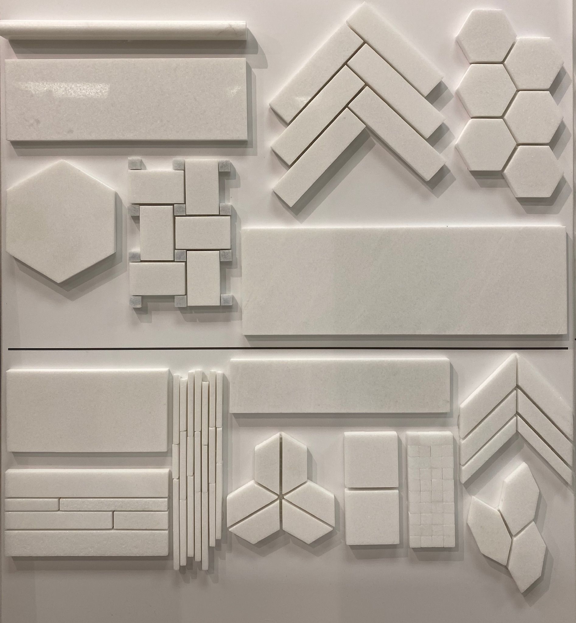 A wall with a variety of white tiles on it