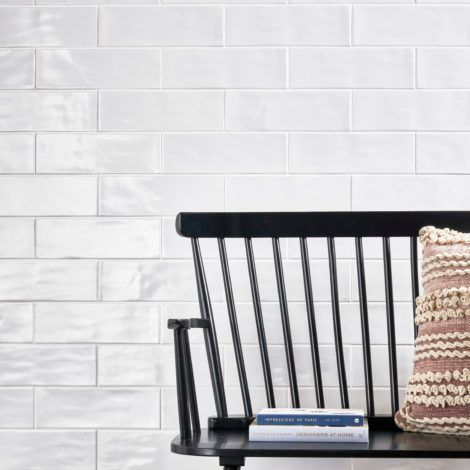 A black wooden bench with a book and a pillow on it.