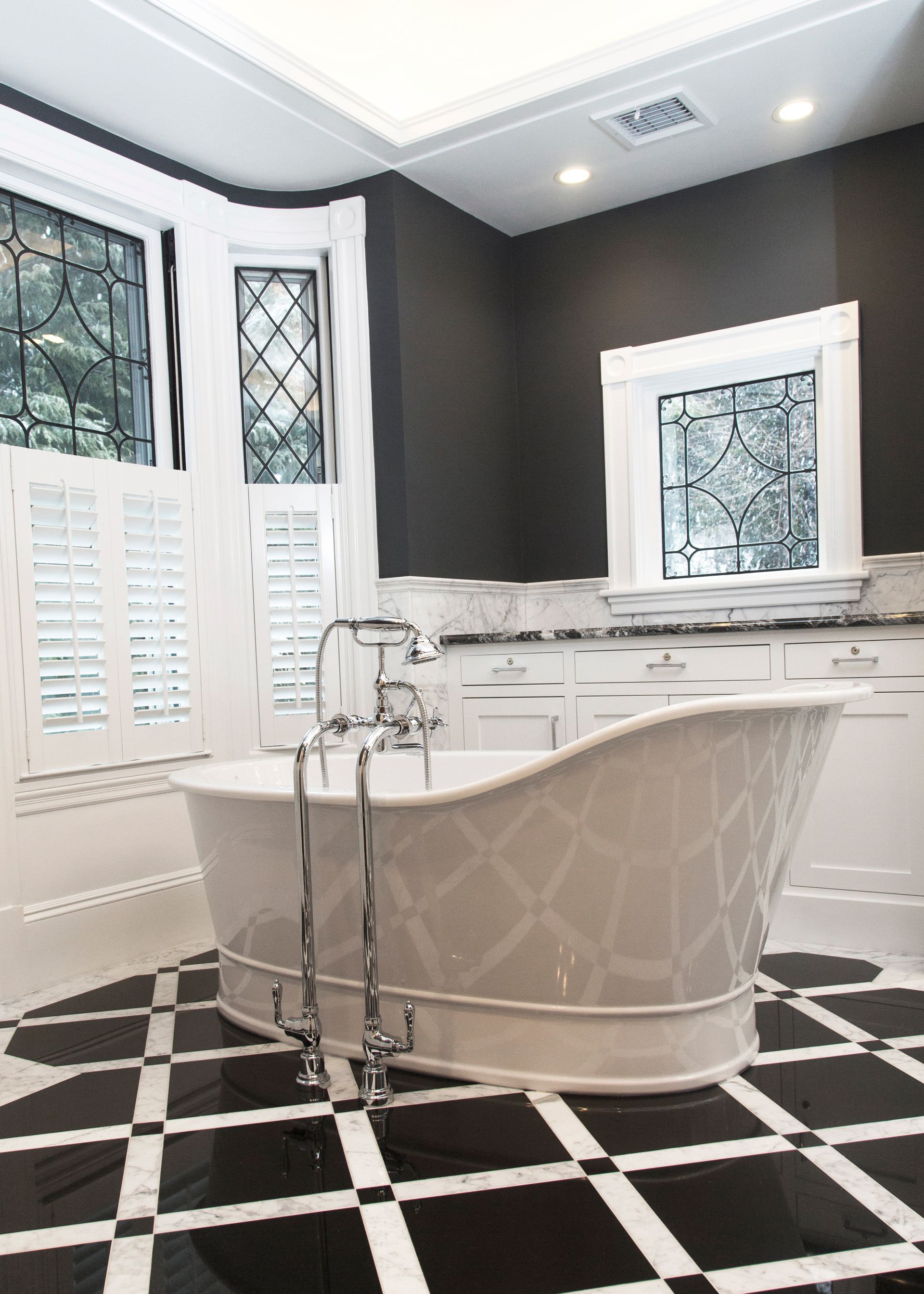 A bathroom with a black and white checkered floor and a bathtub.