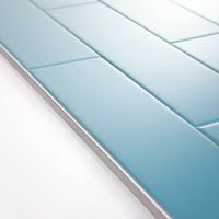 A close up of a blue tile on a white surface.