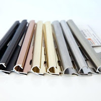 A bunch of metal pipes of different colors are sitting on top of each other on a table.