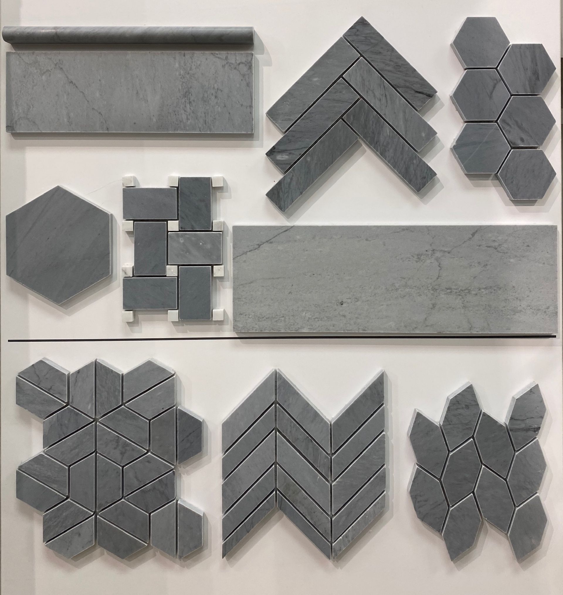 A variety of gray tiles are displayed on a white surface