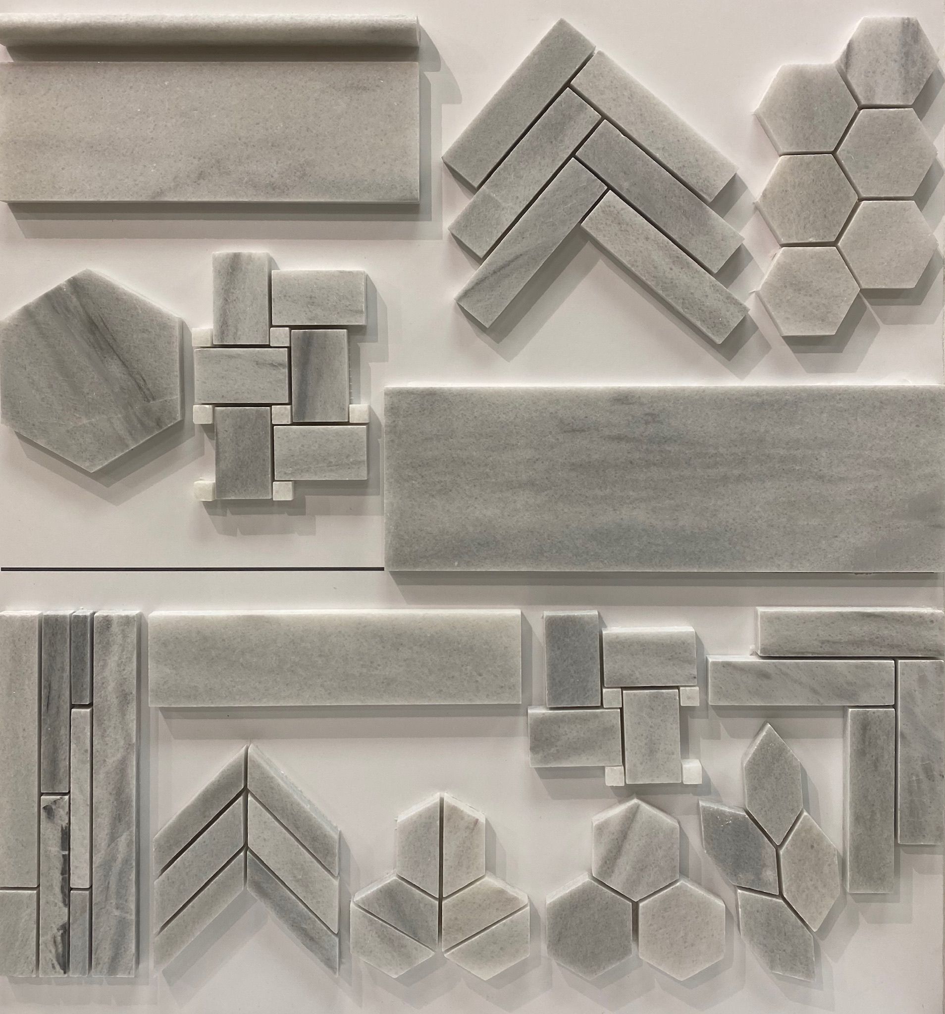 A variety of marble tiles are displayed on a white surface