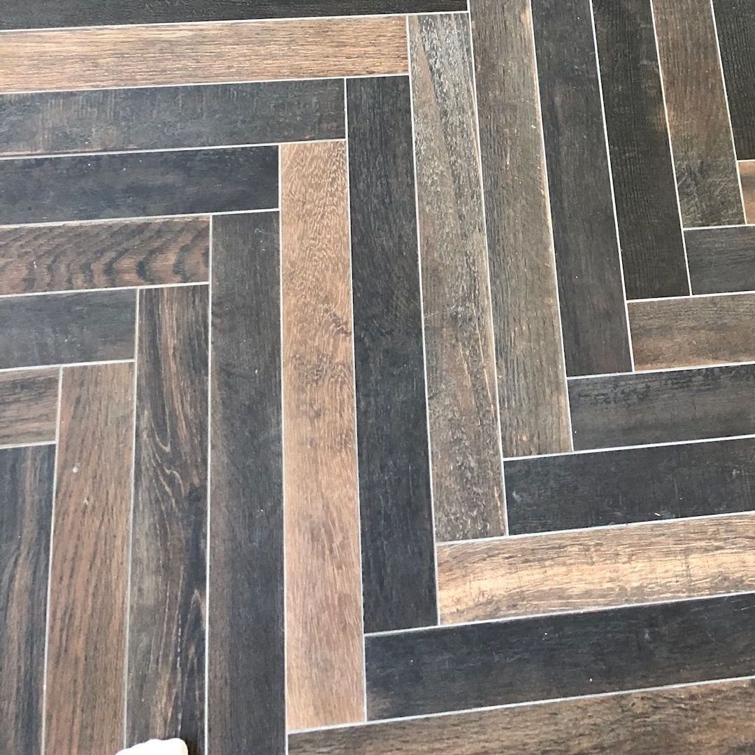 A close up of a wooden floor with a herringbone pattern