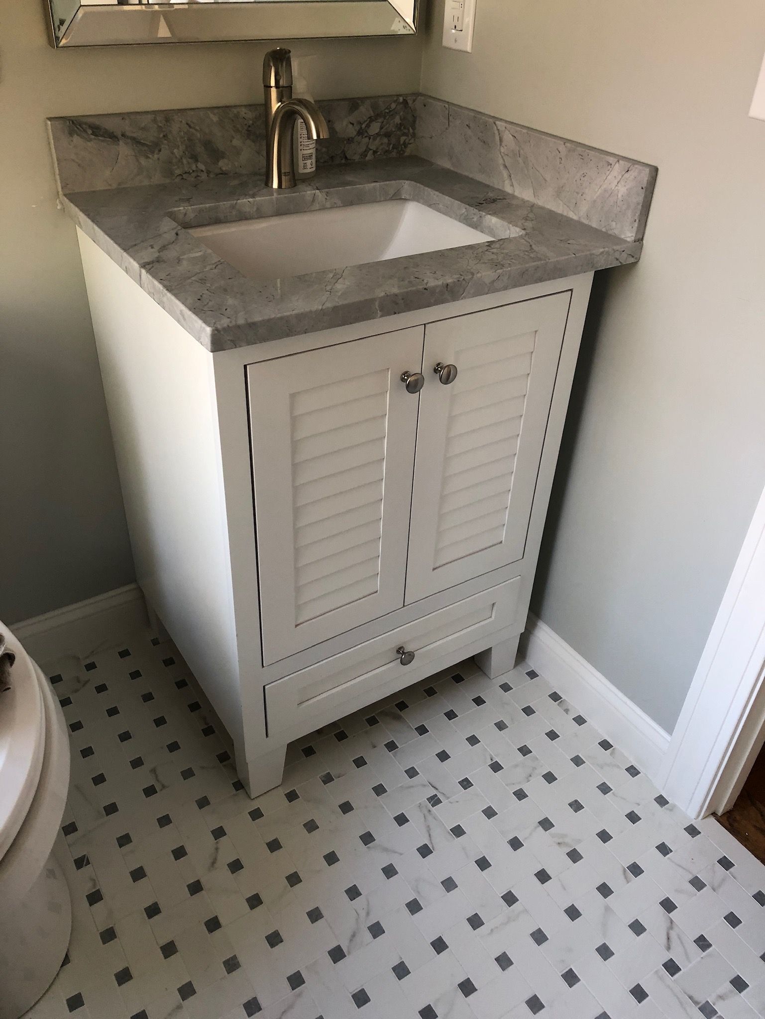 A bathroom with a sink , mirror and toilet