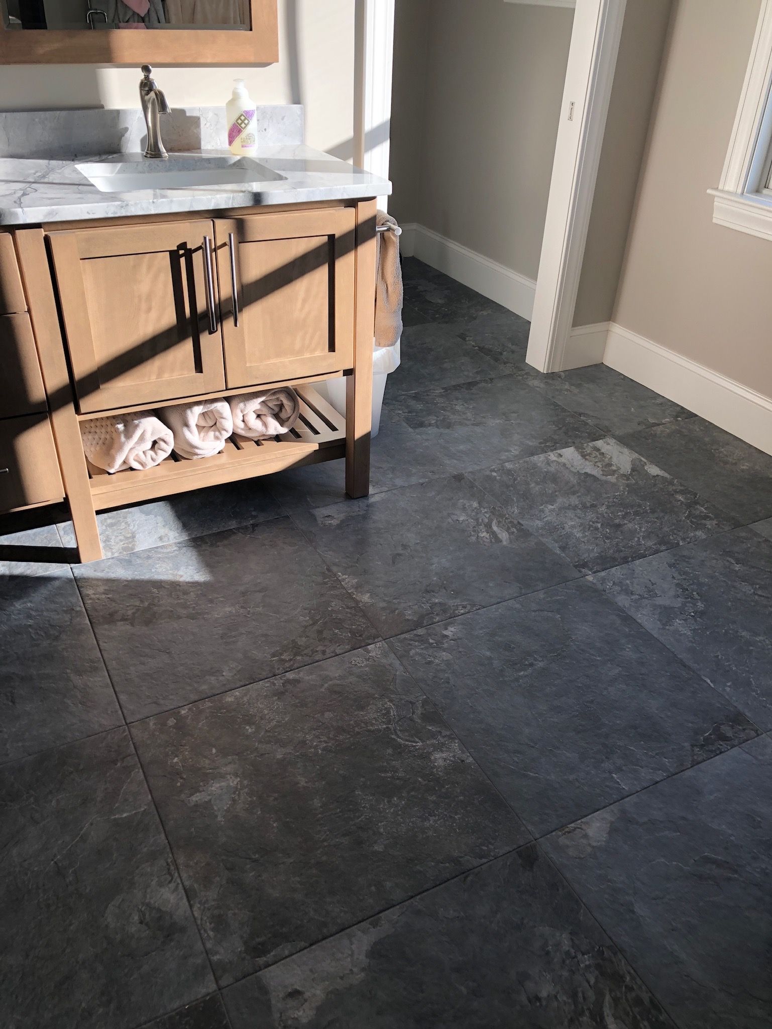 A bathroom with a sink and a wooden cabinet