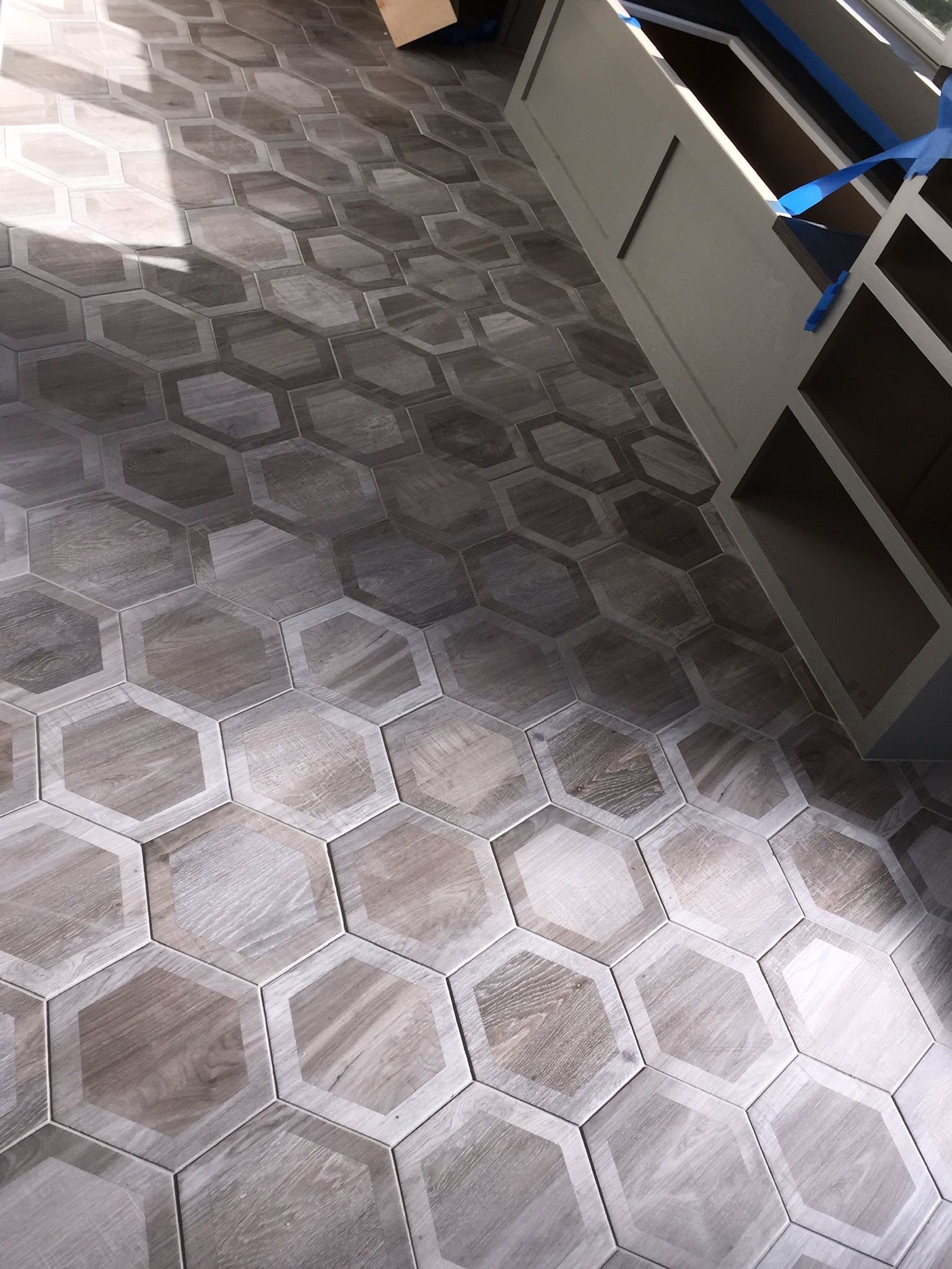 A tiled floor with a hexagon pattern is being installed