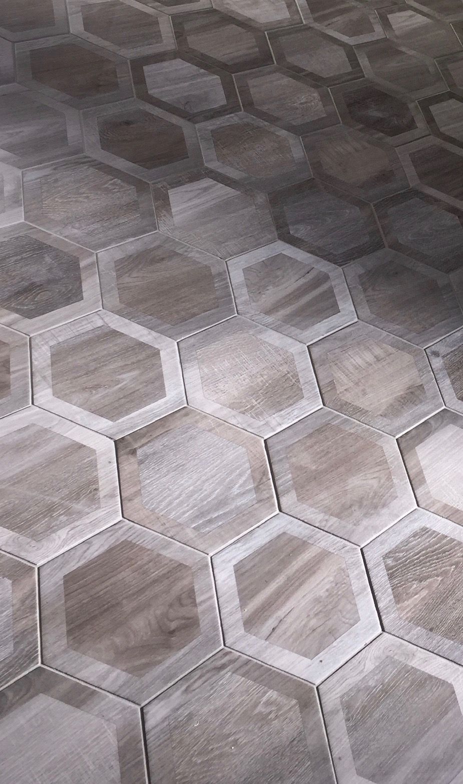A close up of a wooden floor with hexagonal tiles.
