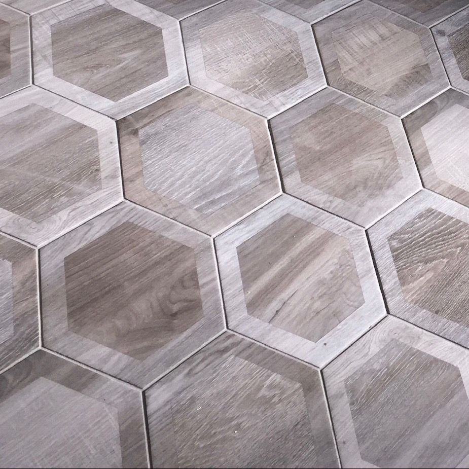 A close up of a wooden floor with hexagonal tiles