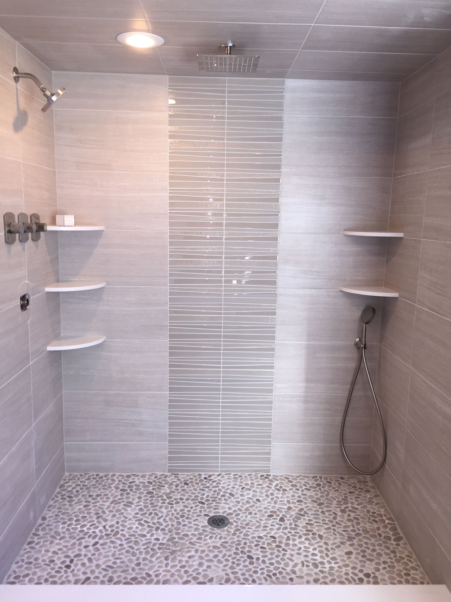 A shower with a tiled floor and a shower head.