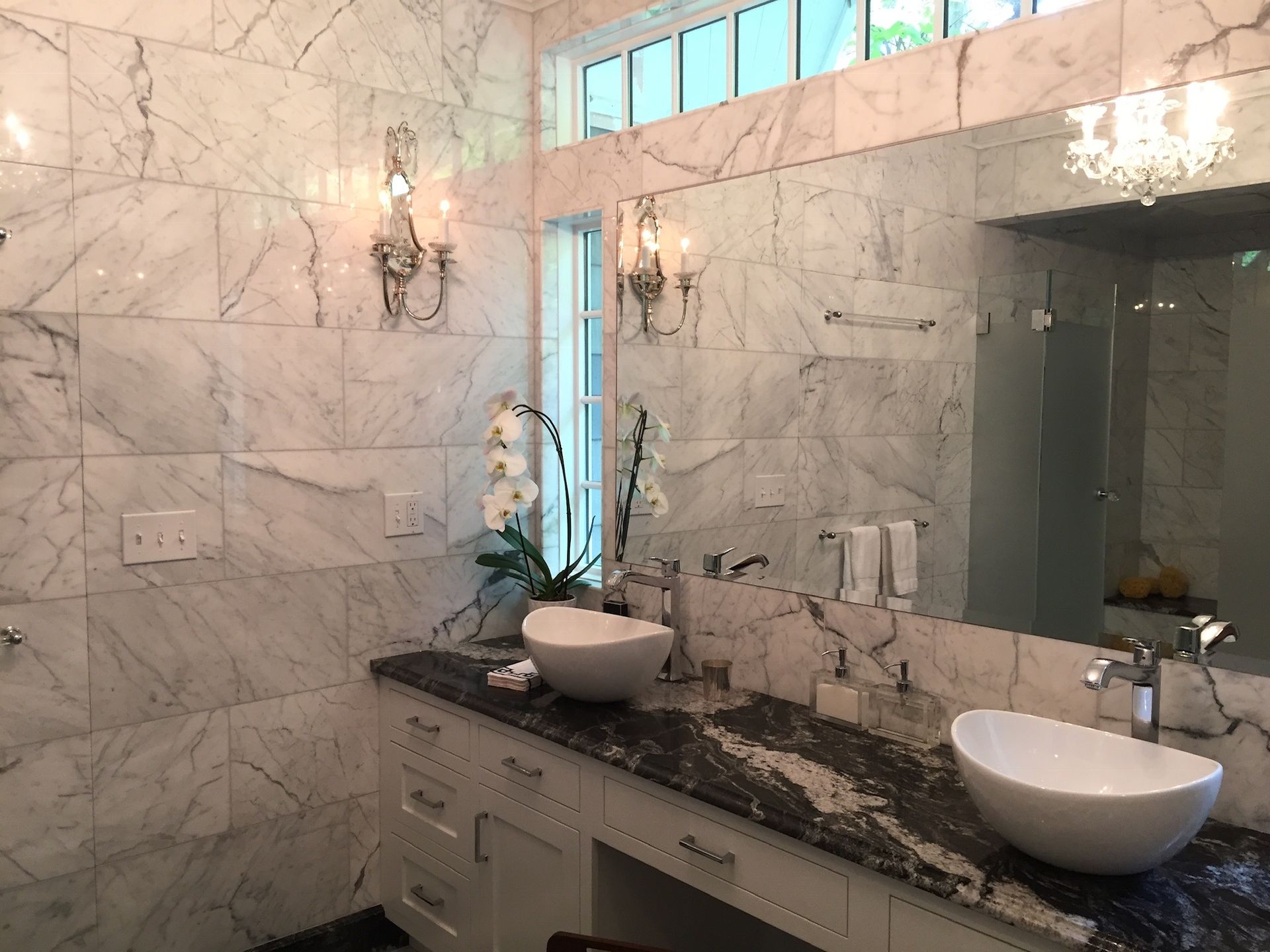 A bathroom with two sinks and a large mirror