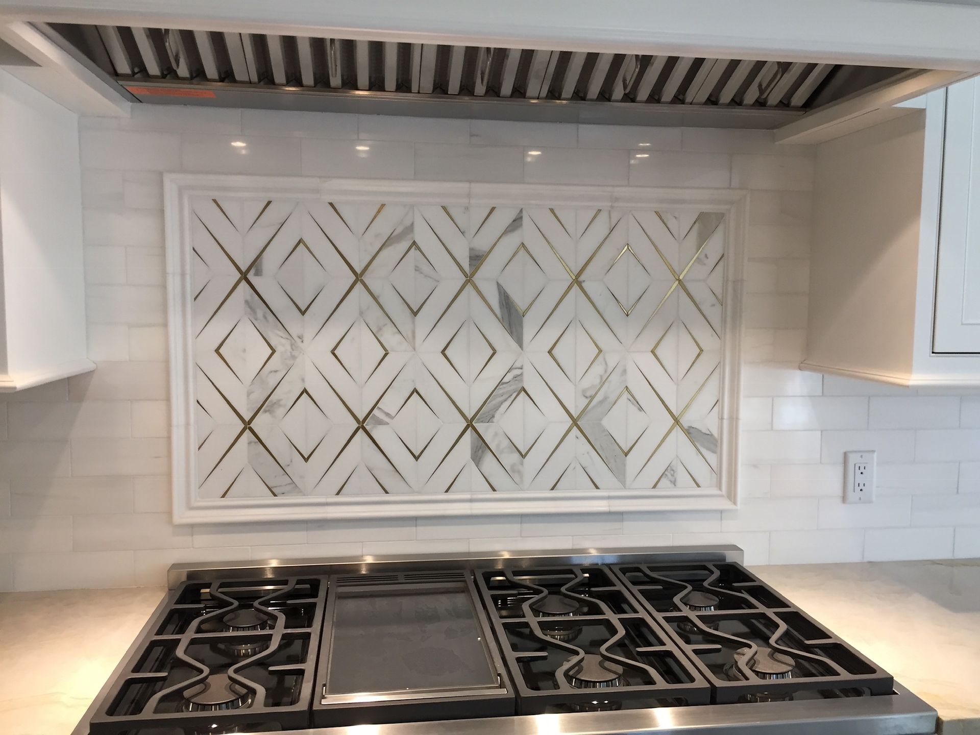 A kitchen with a stove top oven and a picture on the wall above it.