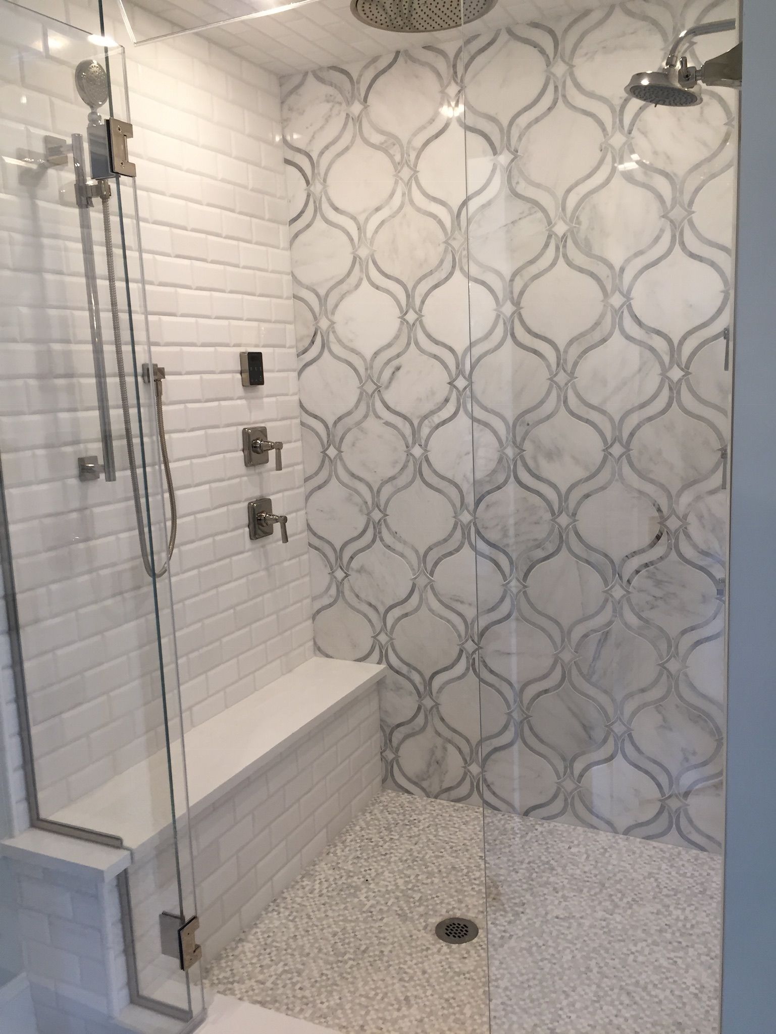 A bathroom with a walk in shower and a bench.