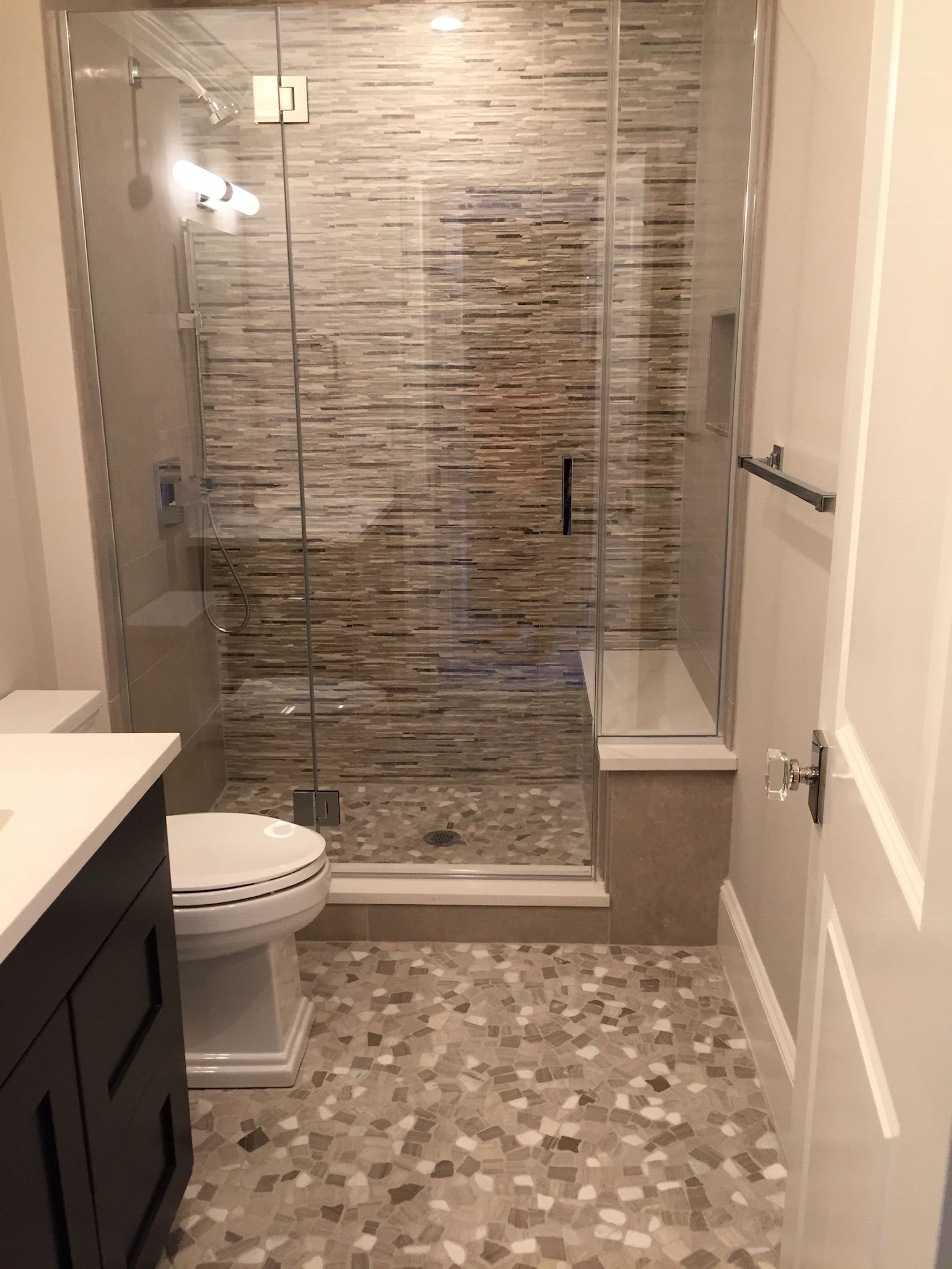 A bathroom with a toilet , sink , and walk in shower.
