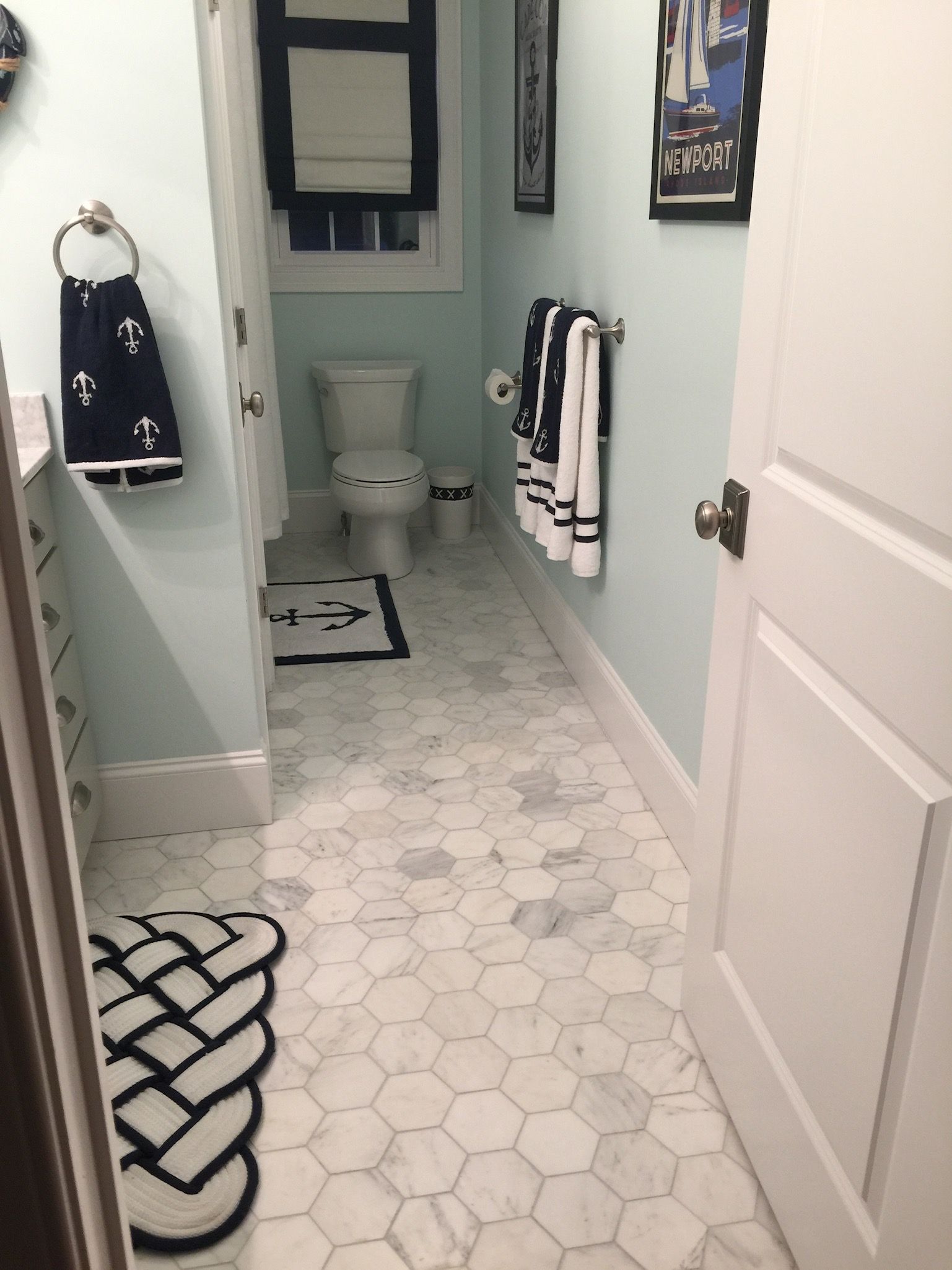 A bathroom with a toilet and a rug on the floor
