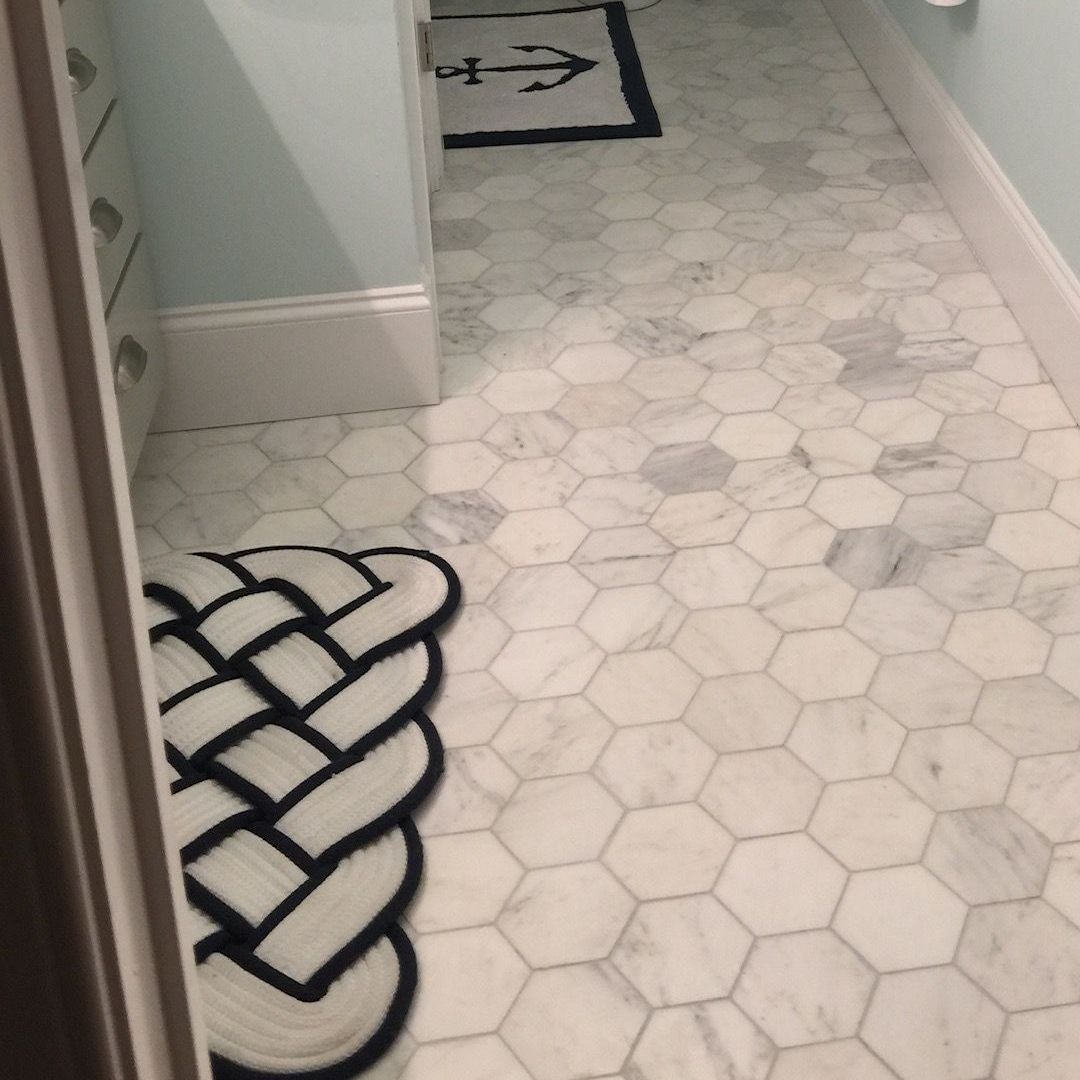 A black and white rug is on the floor of a bathroom