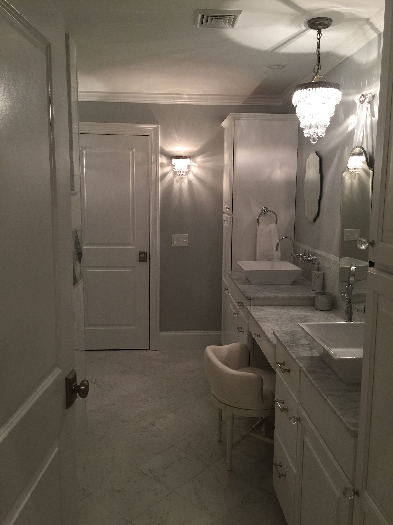 A bathroom with two sinks and a chair in it