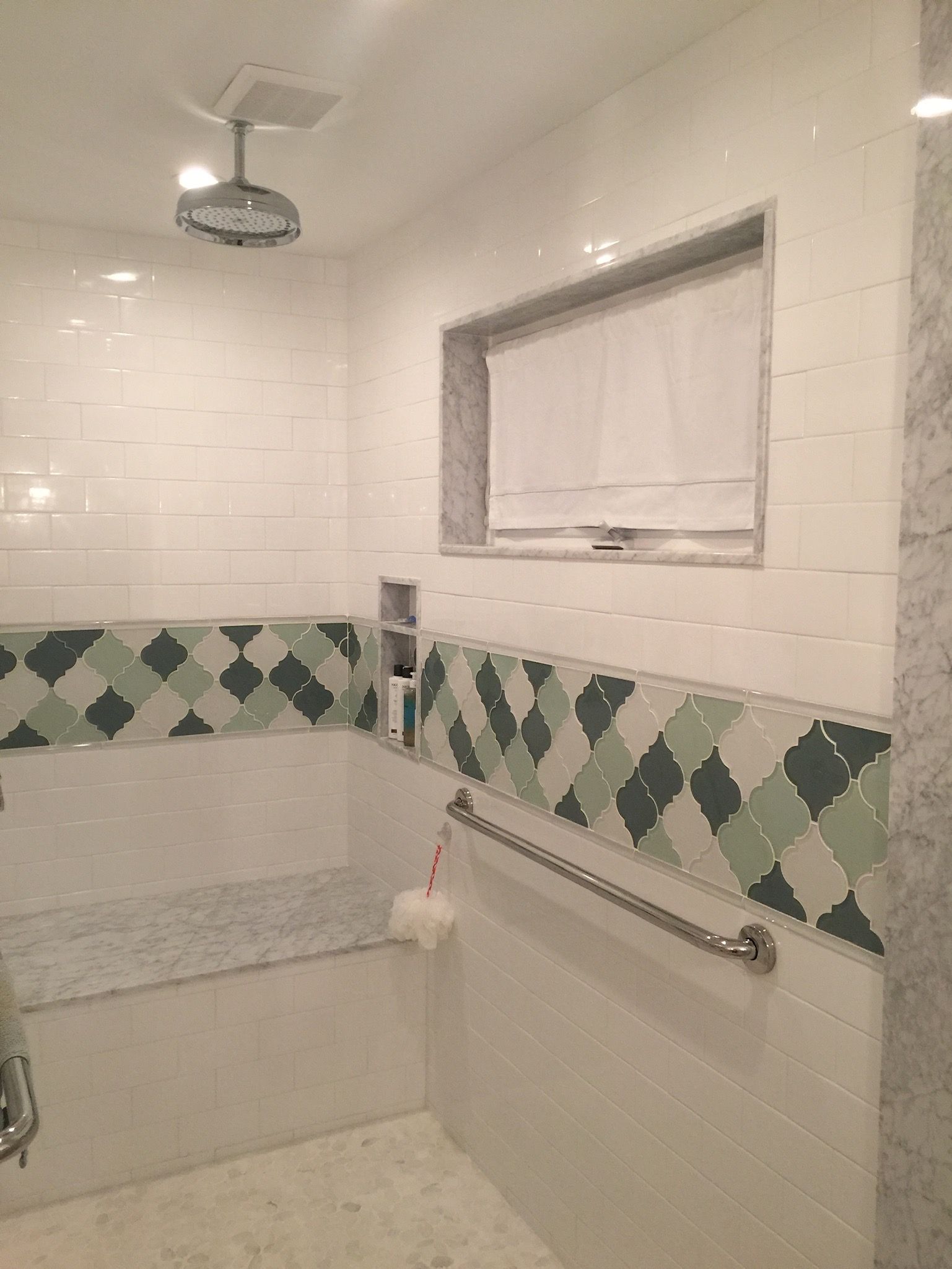 A bathroom with a walk in shower and a window.