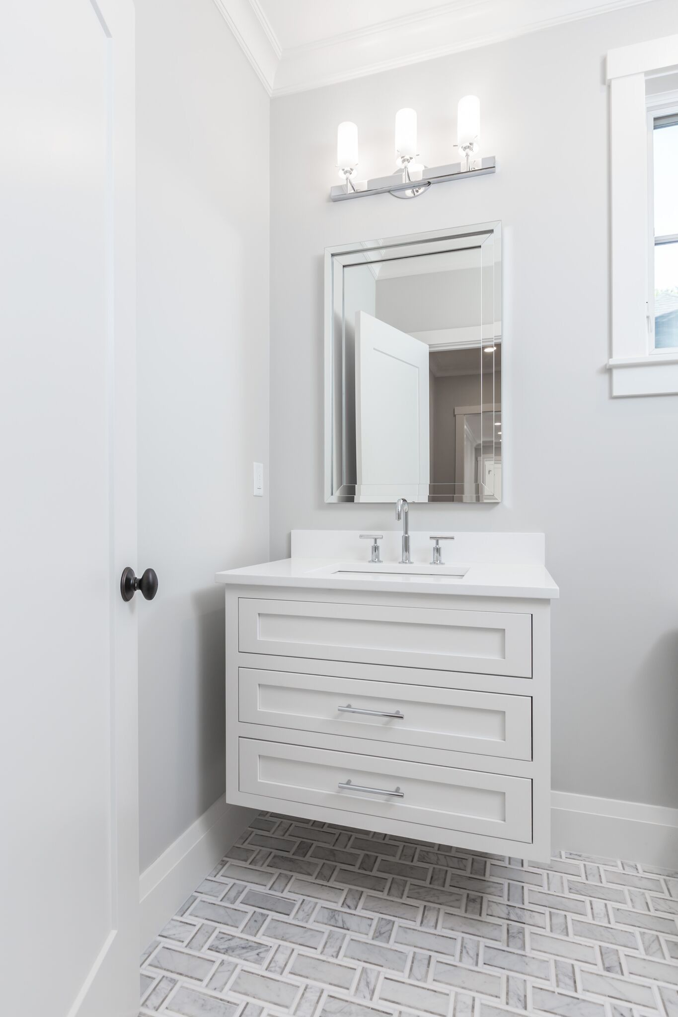 A bathroom with a sink , mirror and light fixture.