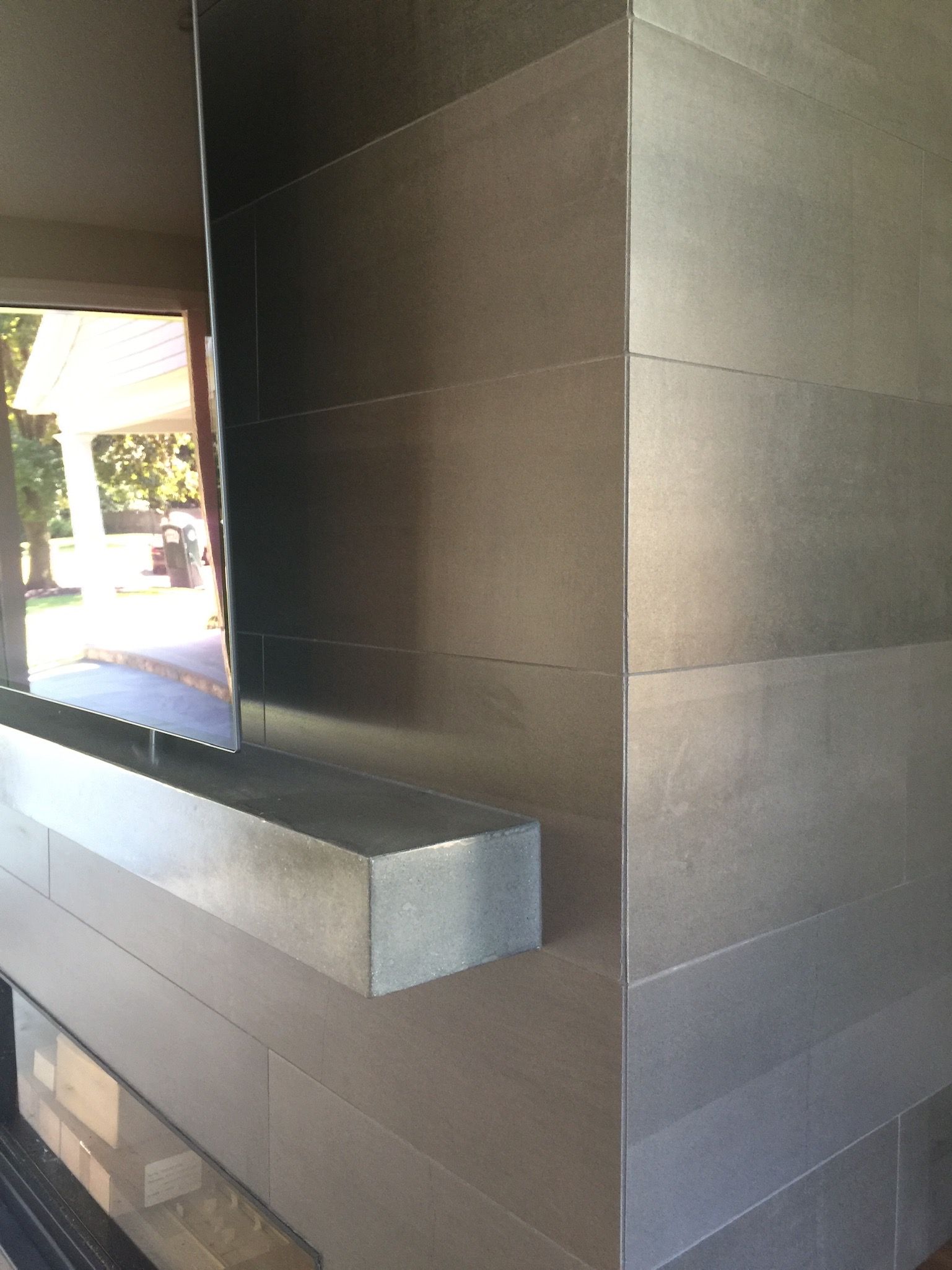 A corner of a room with a fireplace and a window