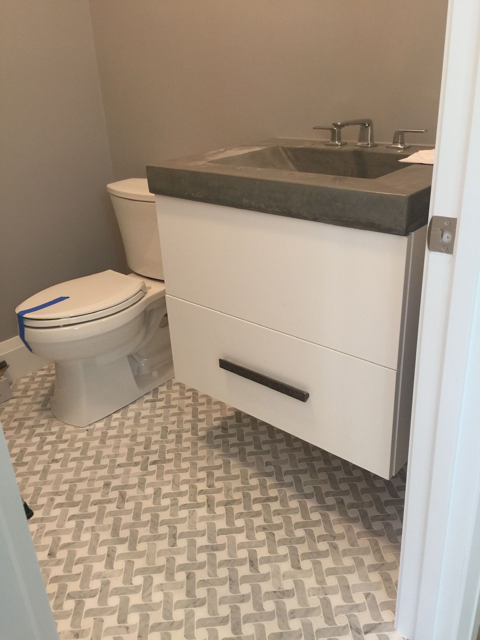 A bathroom with a toilet , sink and vanity.