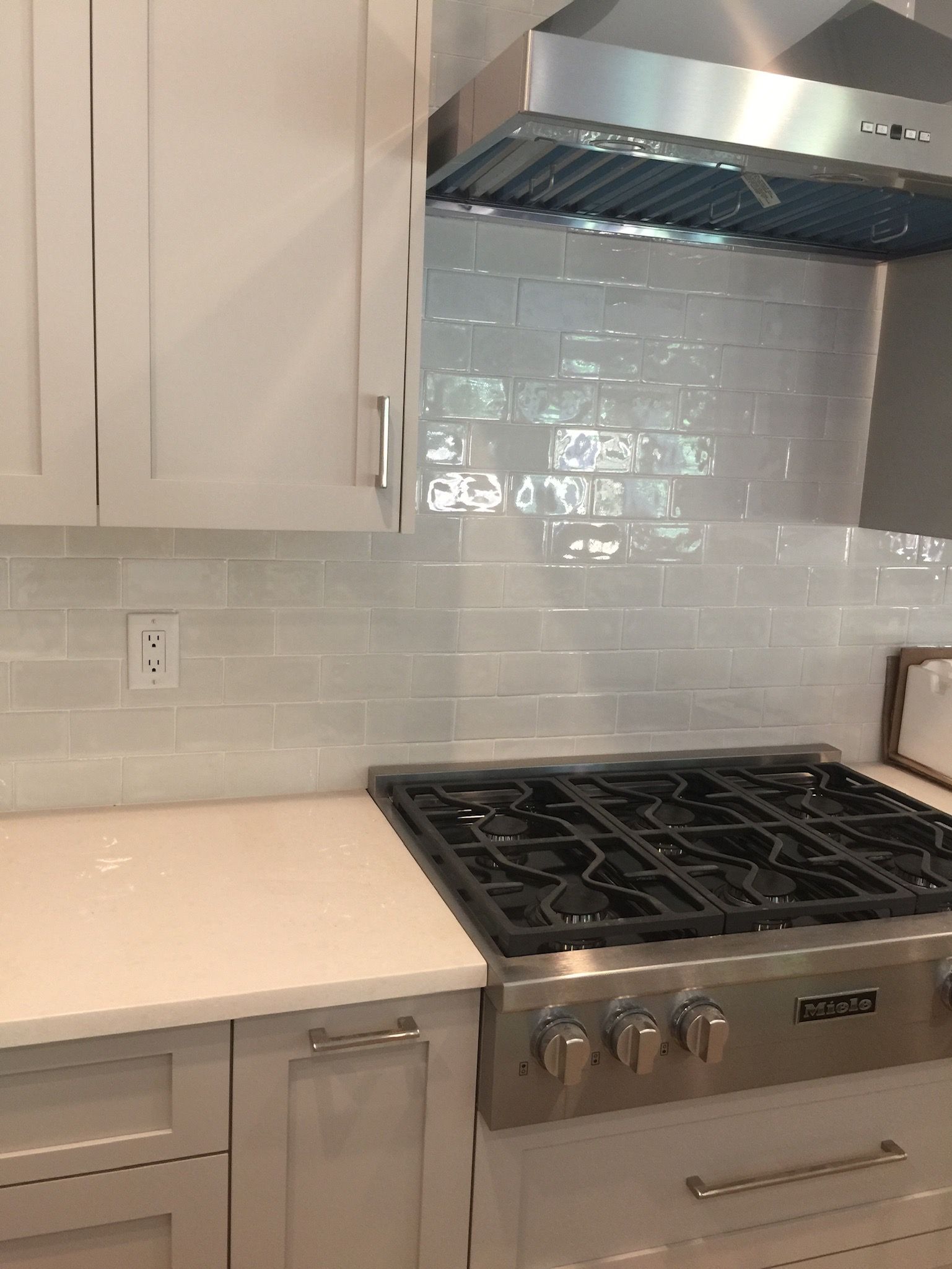A kitchen with a stove top oven and white cabinets