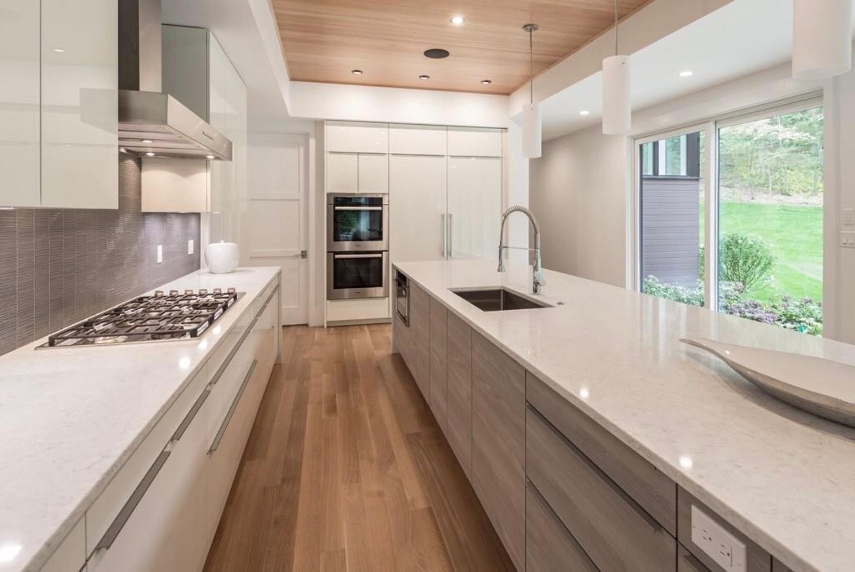 A kitchen with white cabinets , stainless steel appliances , a sink and a stove.