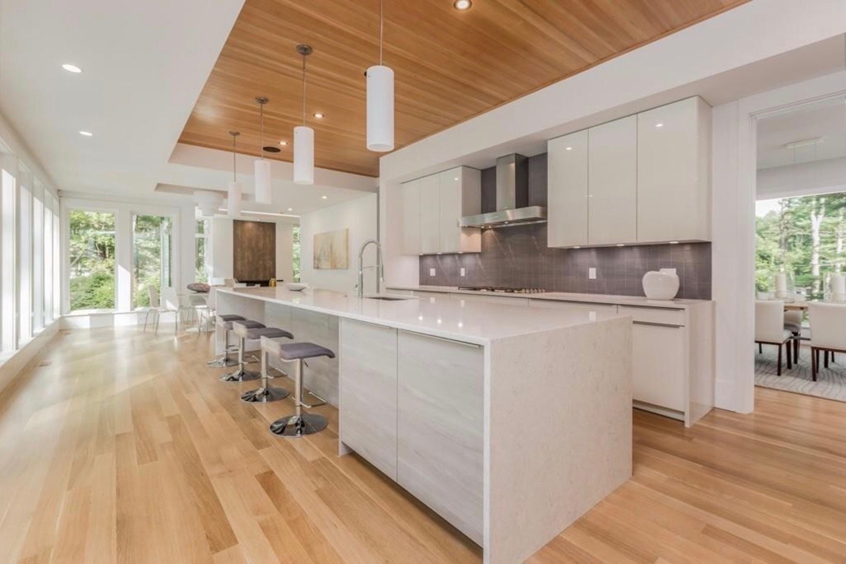 A modern kitchen with a large island and wooden floors.