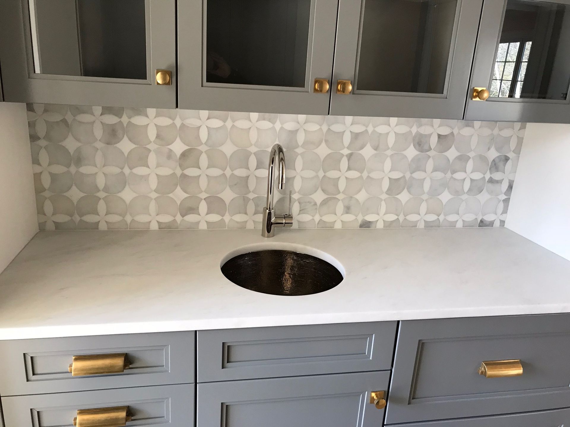A kitchen with a sink , cabinets and drawers.