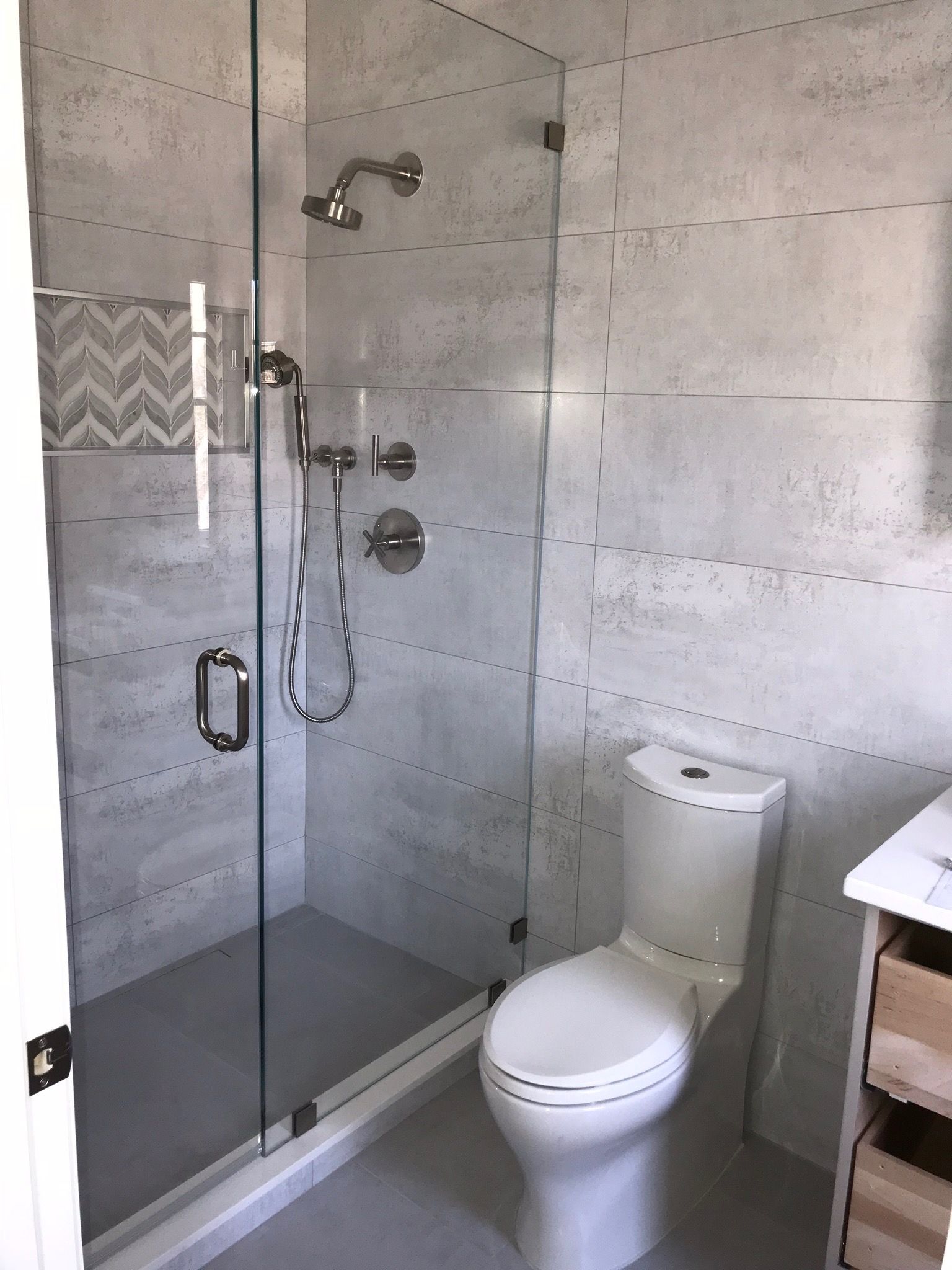 A bathroom with a toilet and a shower with a glass door.