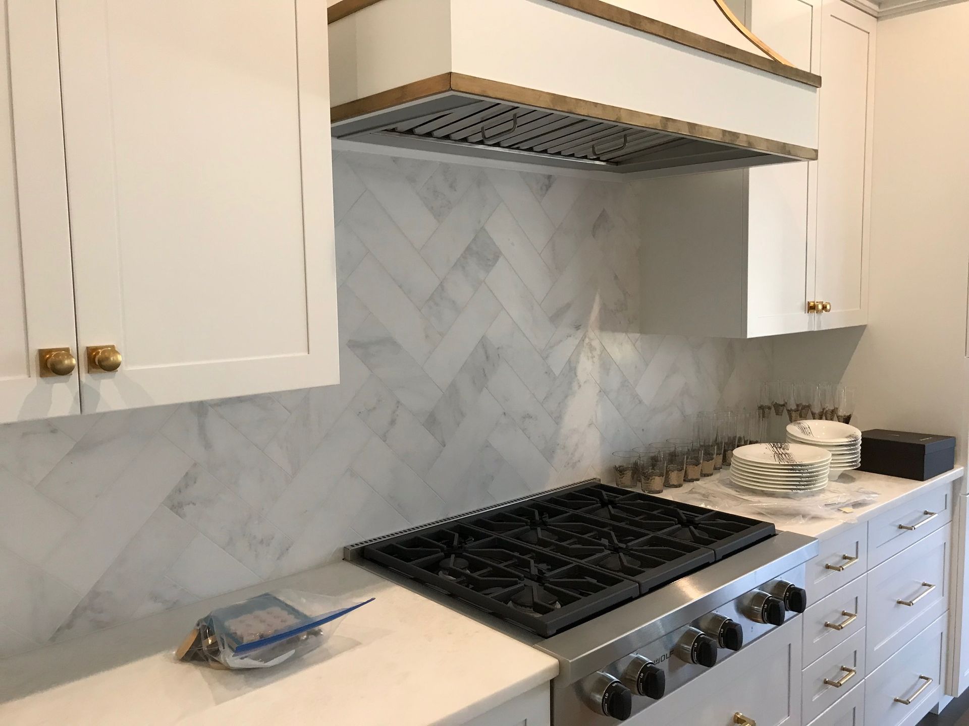 A kitchen with white cabinets and a stove top oven.