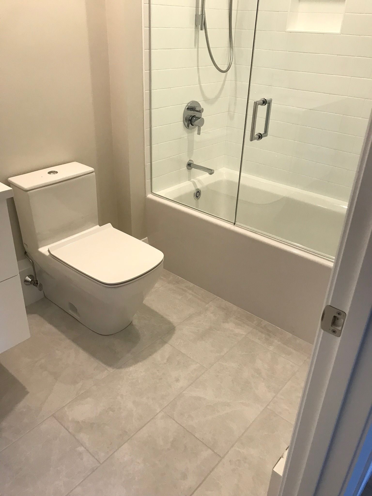 A bathroom with a toilet , tub and shower.