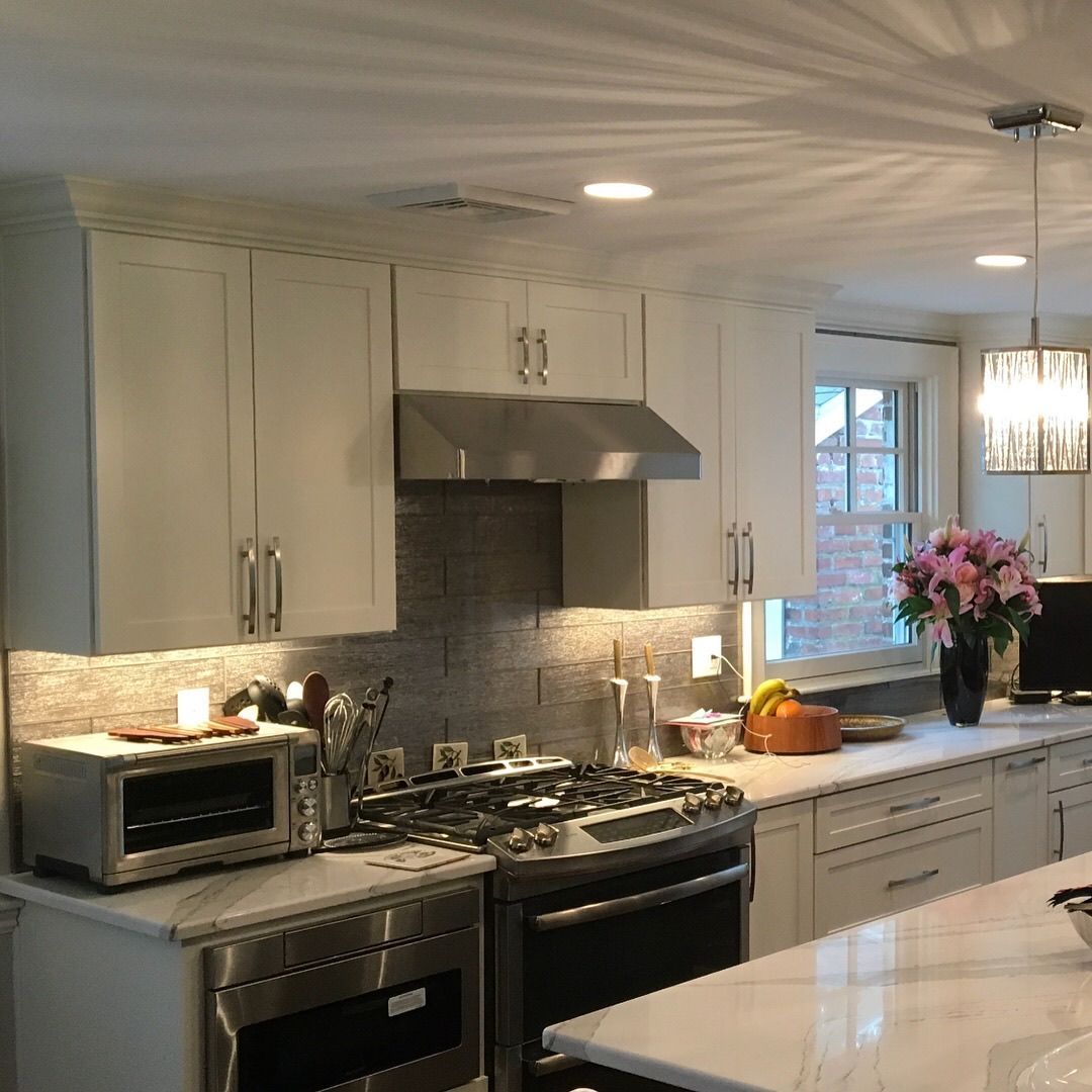 A kitchen with white cabinets and stainless steel appliances