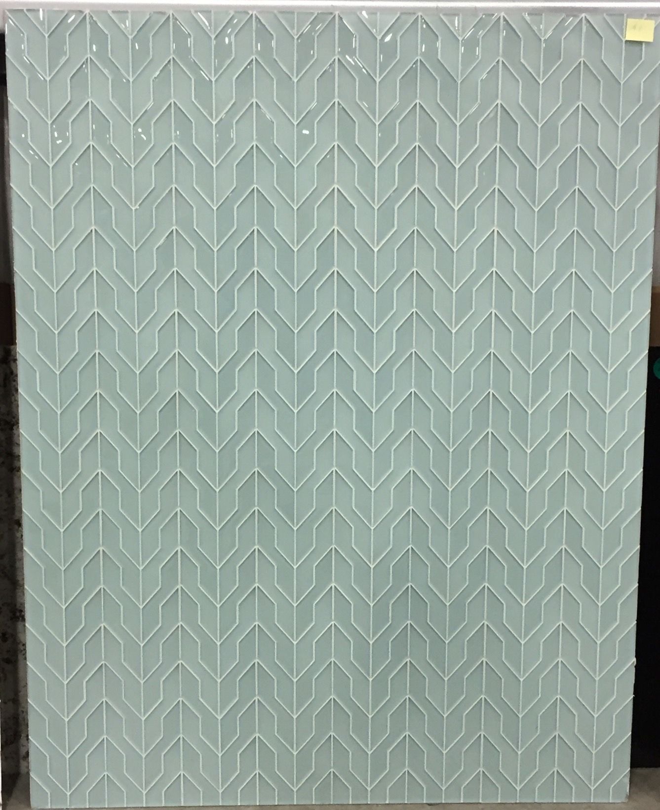 A tile with a herringbone pattern is sitting on a table.