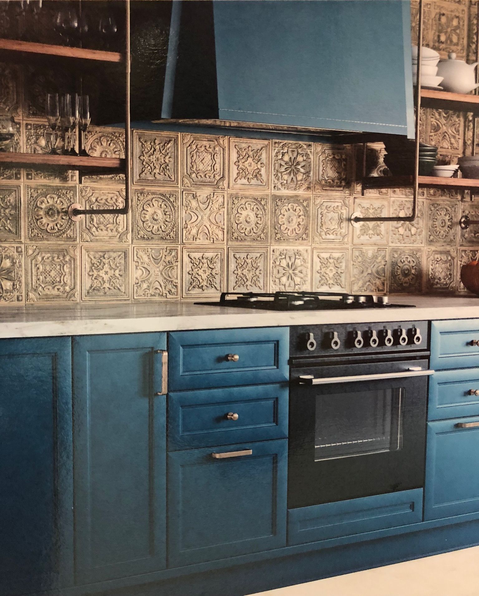 A kitchen with blue cabinets and black appliances