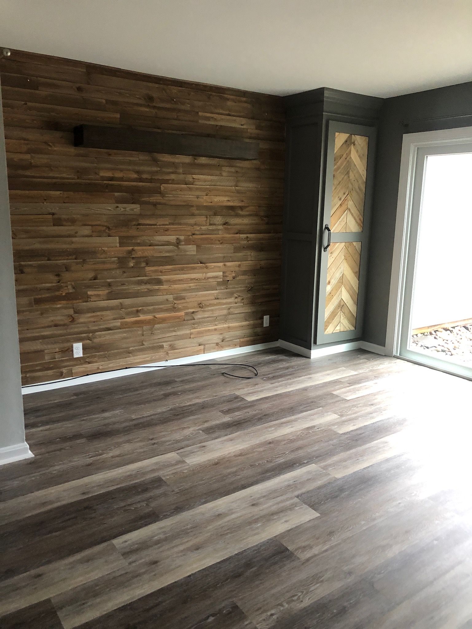 A living room with wooden floors and a wooden wall