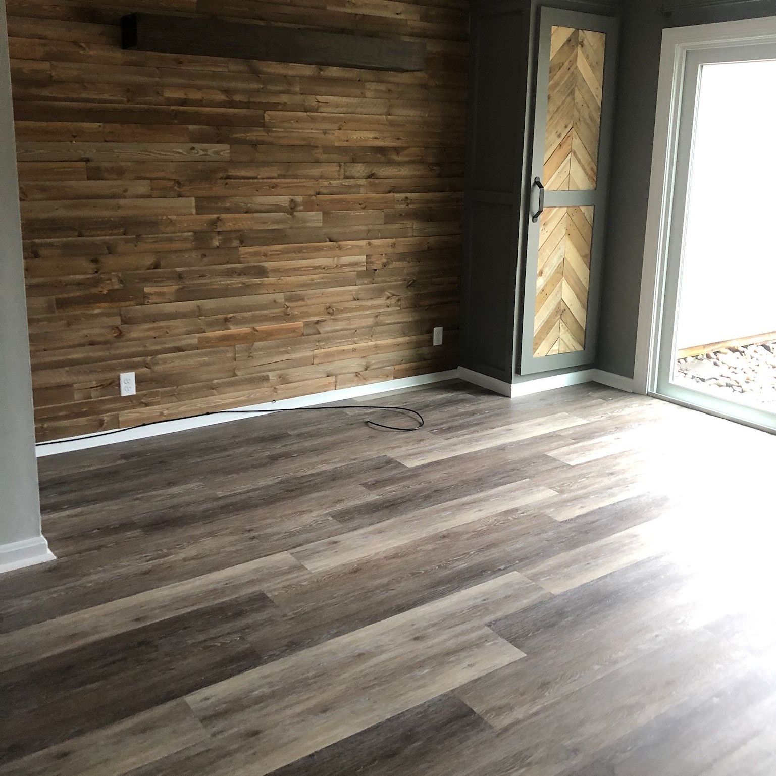 A living room with hardwood floors and a wooden wall.