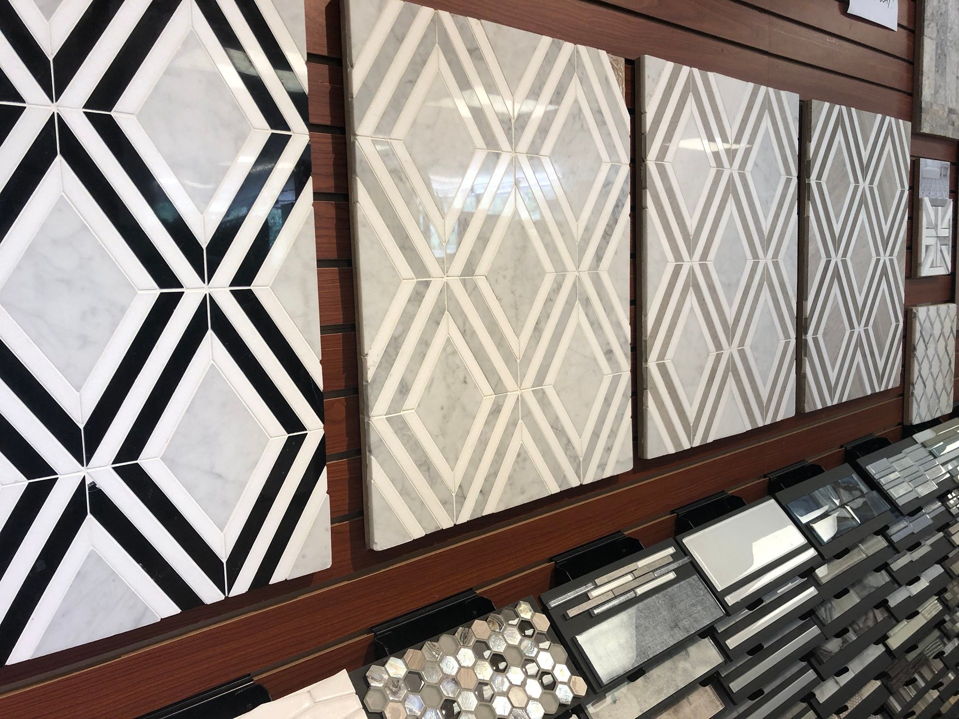 A display of tiles with geometric designs on a wall.