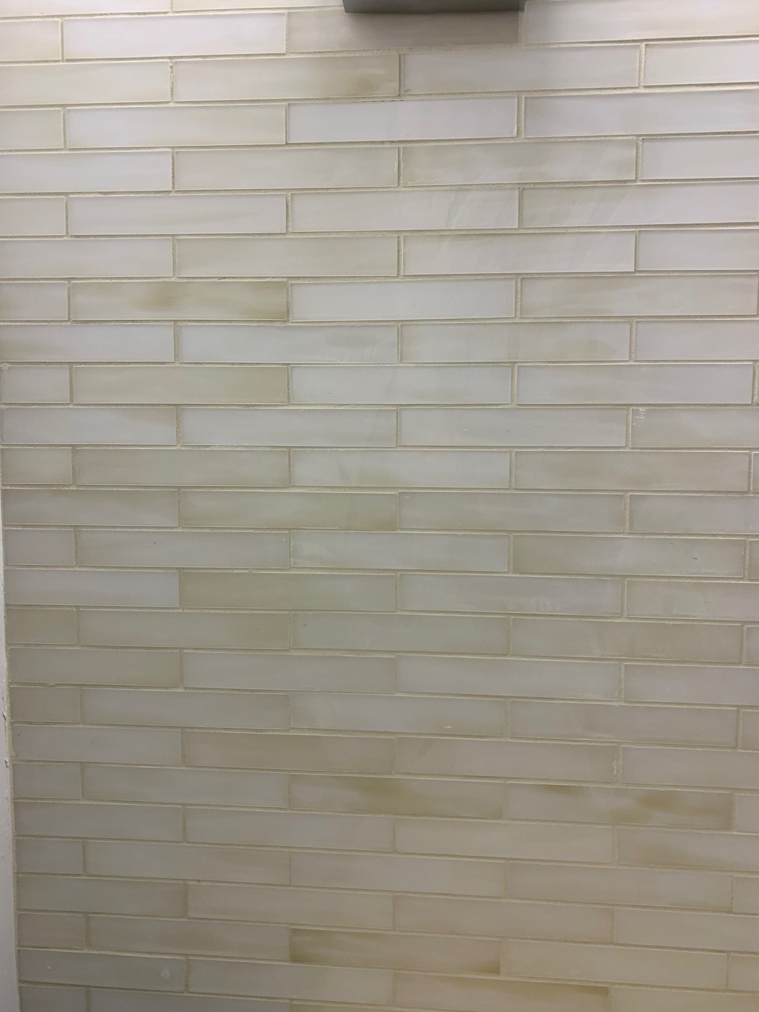 A white brick wall with a lot of tiles on it.