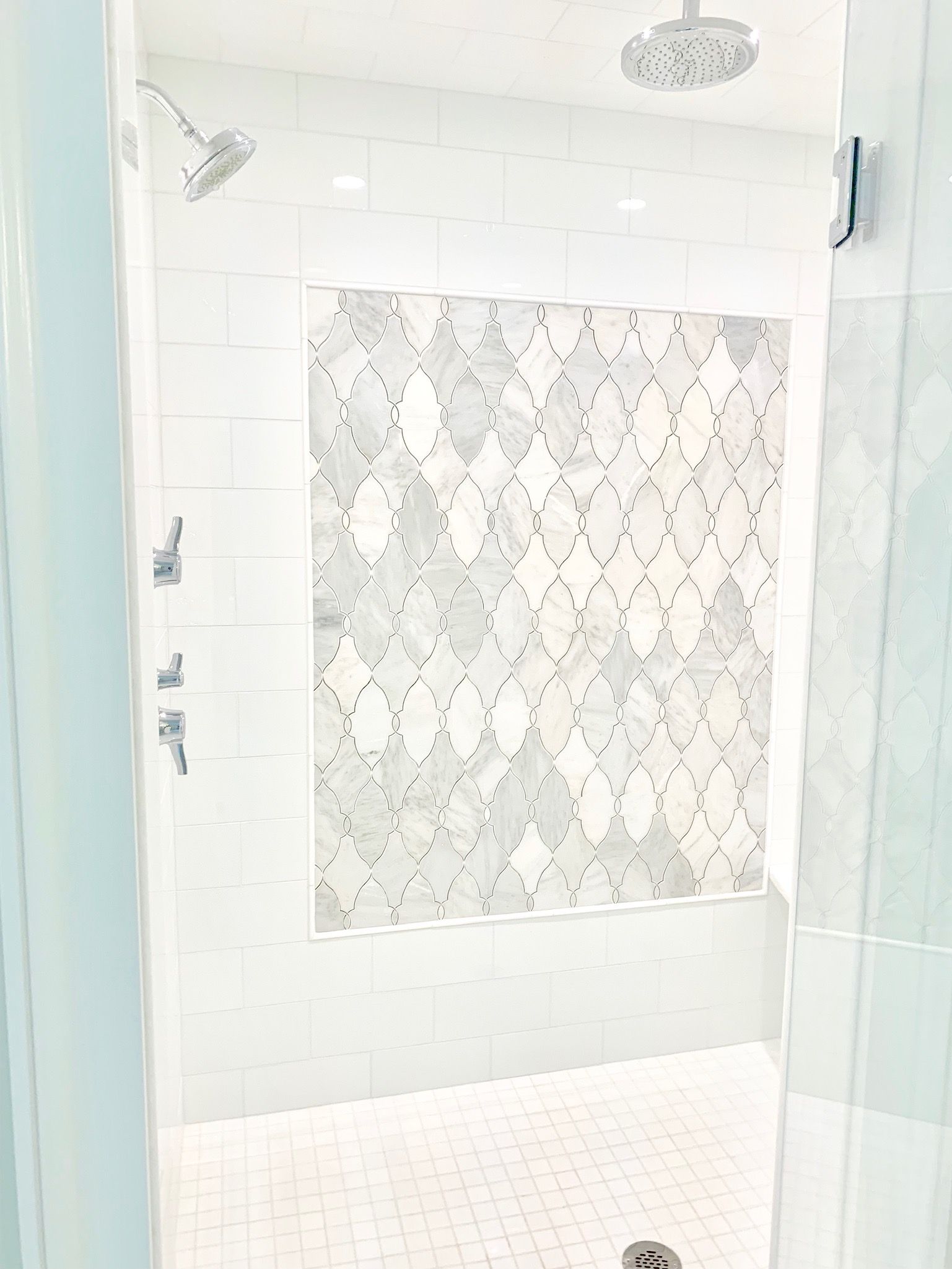 A bathroom with a walk in shower and a shower head.