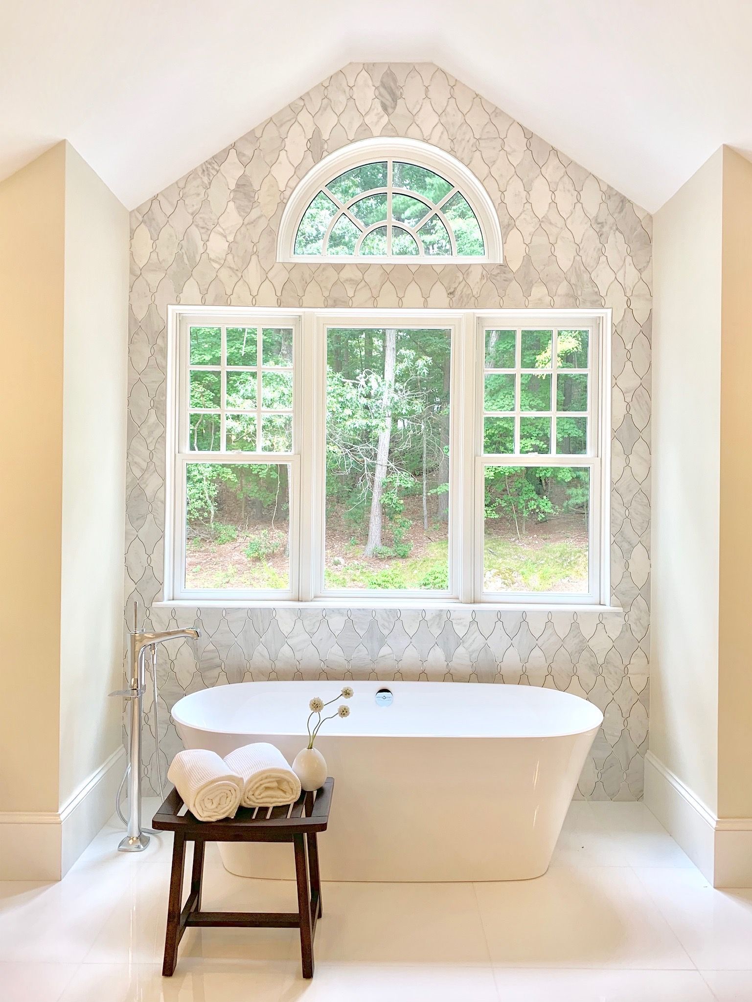 A bathroom with a bathtub and a window.
