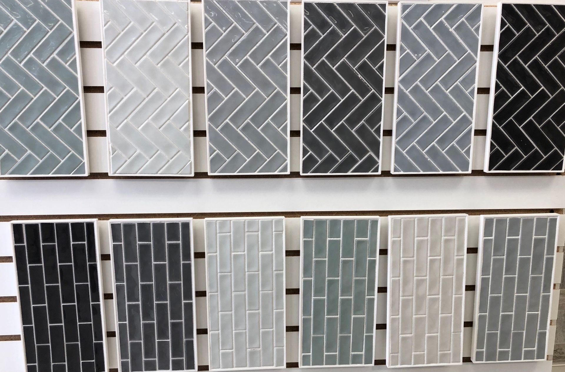 A display of subway tiles of different colors and patterns