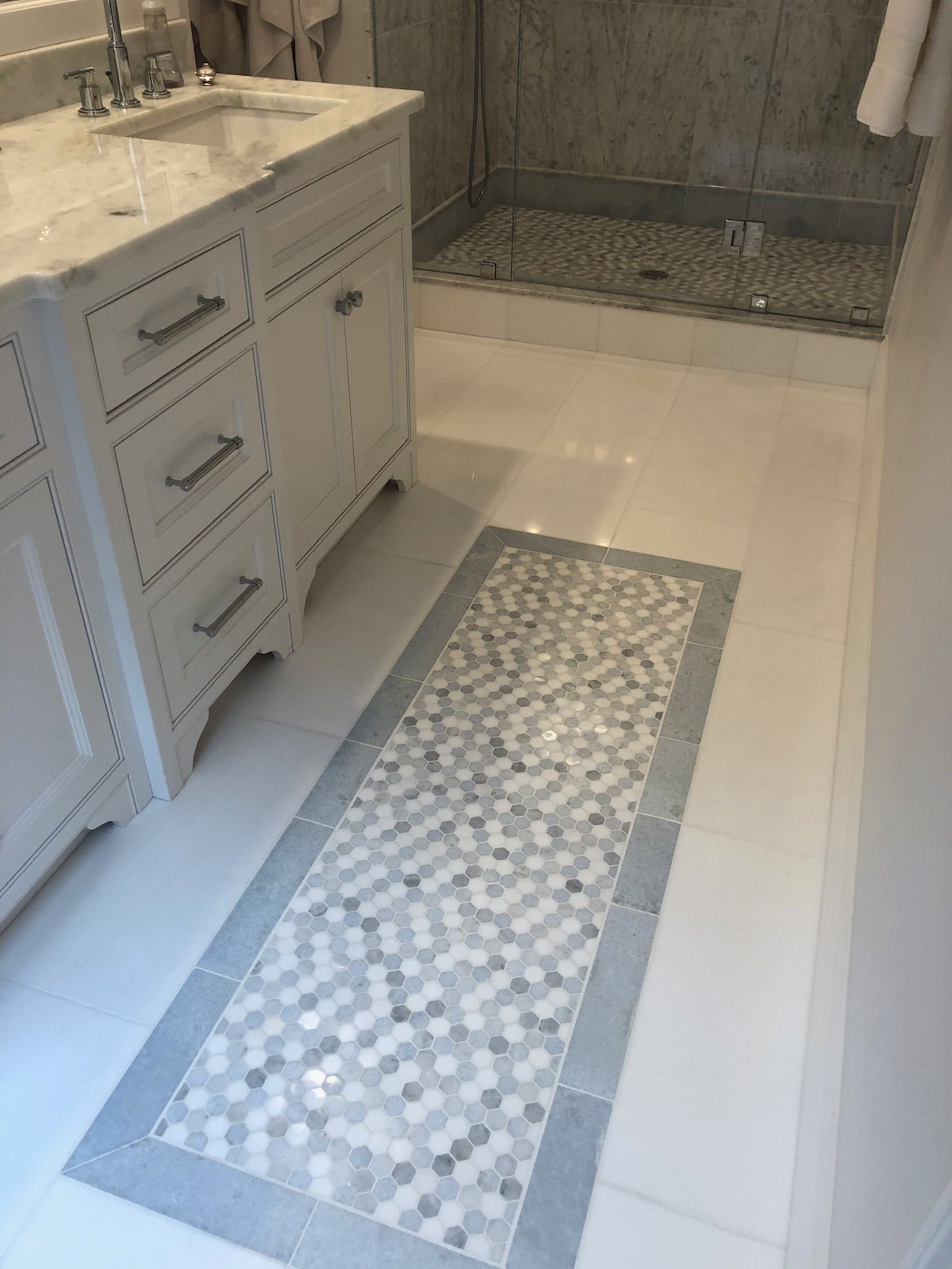 A bathroom with two sinks and a walk in shower