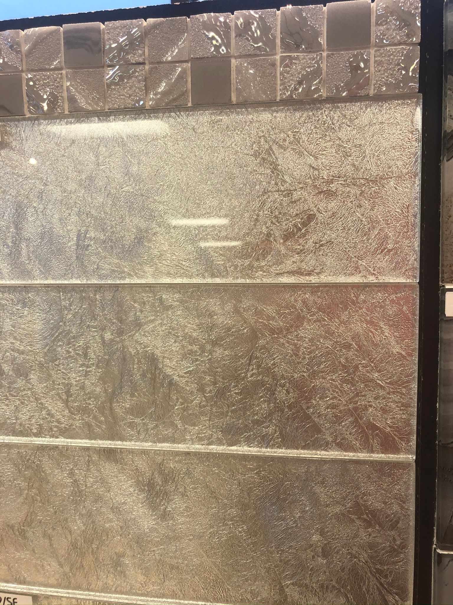 A close up of a glass door with a brick wall in the background.