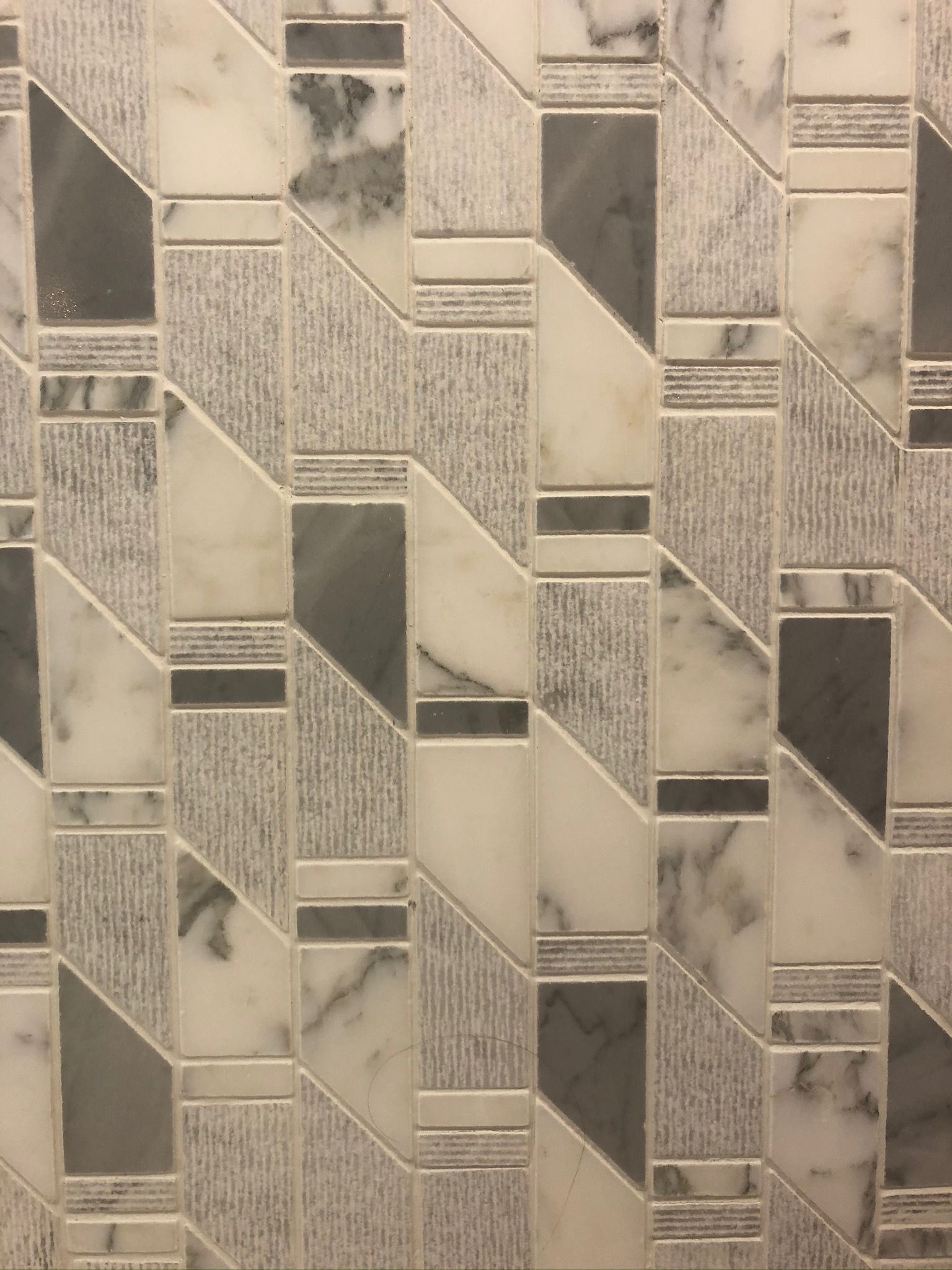 A close up of a tile wall with a geometric pattern.