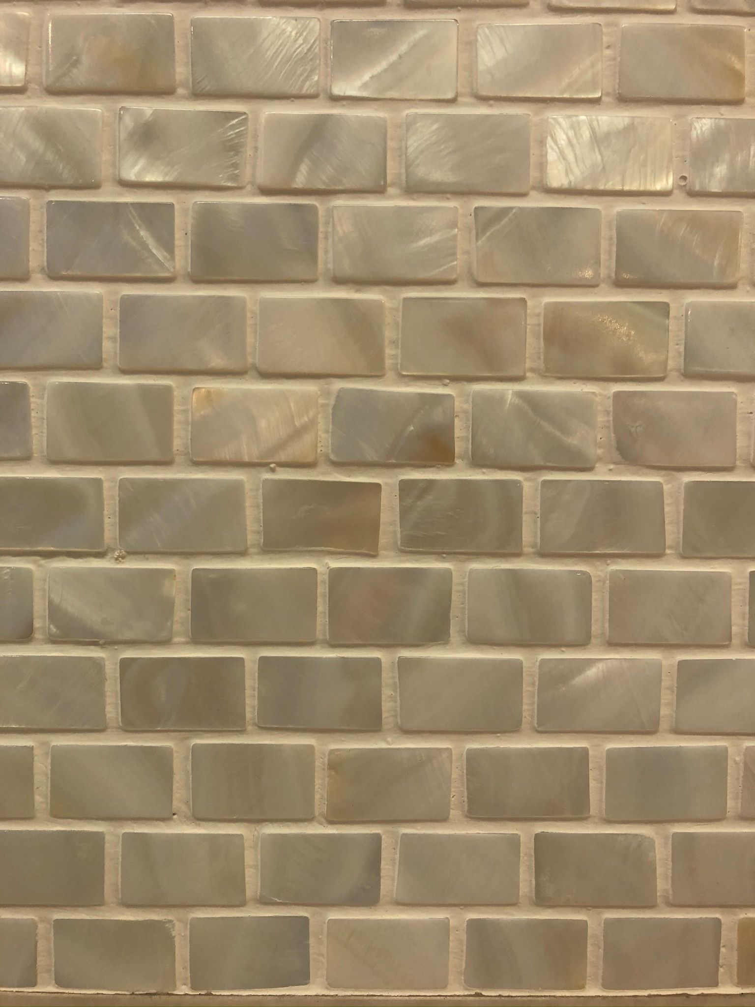A close up of a brick wall with square tiles on it.