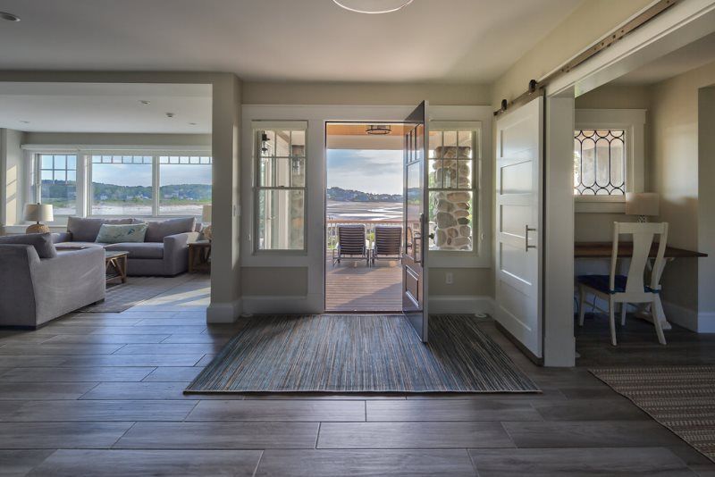 A living room with a view of the ocean and a sliding barn door.