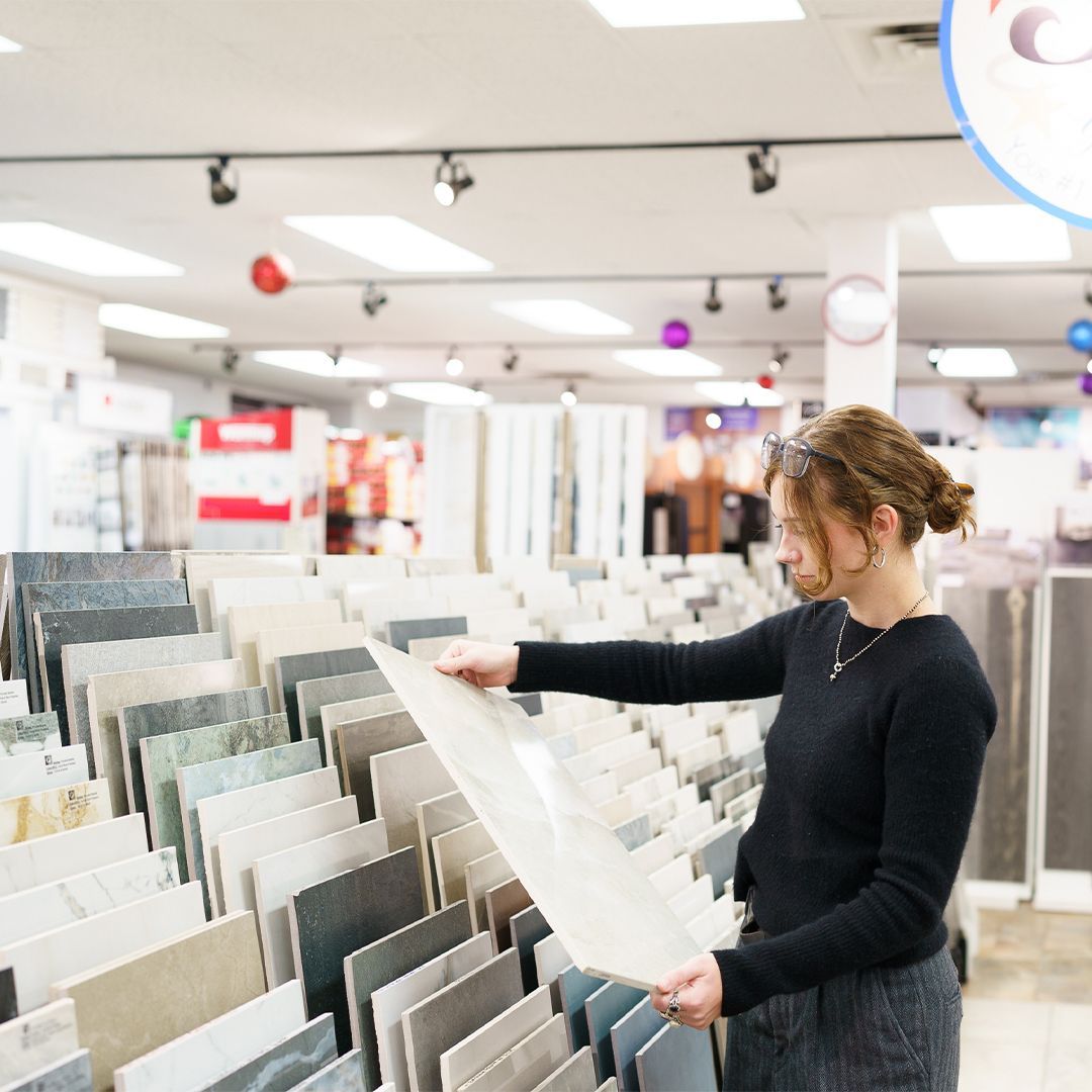 A woman is looking at tiles in a store.