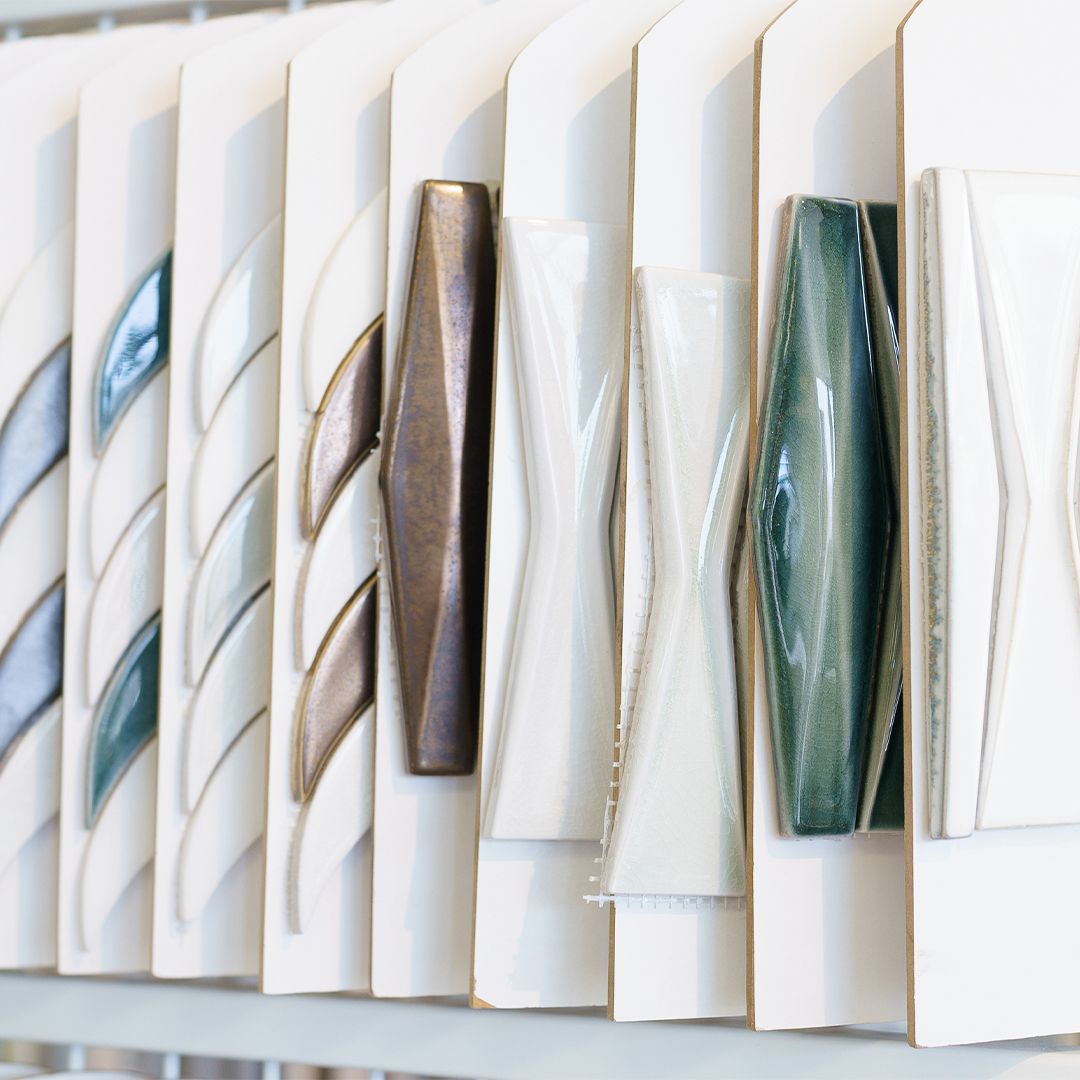 A row of ceramic vases are lined up on a shelf