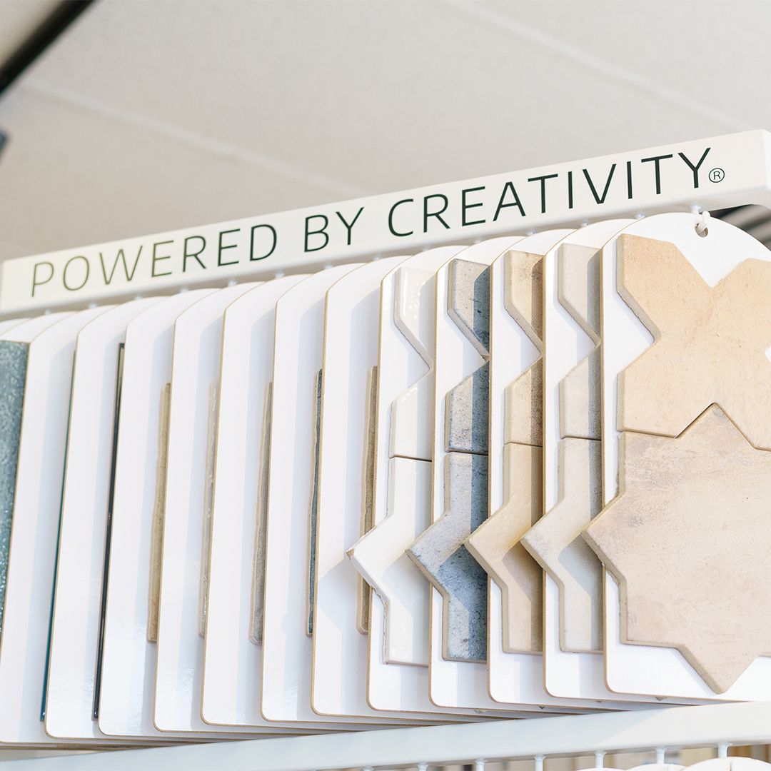 A sign that says powered by creativity above a display of tiles